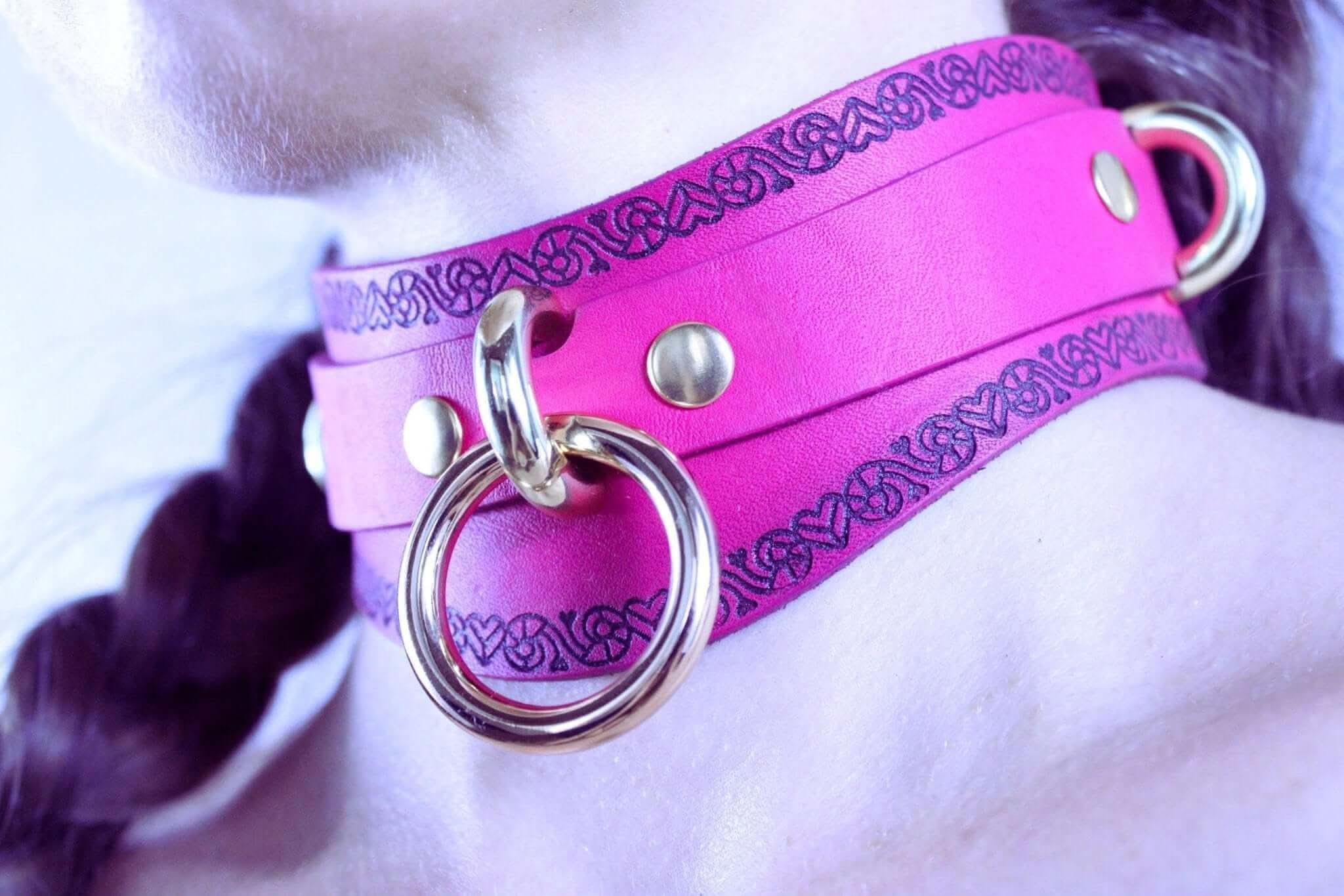 Handcrafted pink BDSM choker collar with heart motif and O-ring, perfect for submissive jewelry and bondage attire.