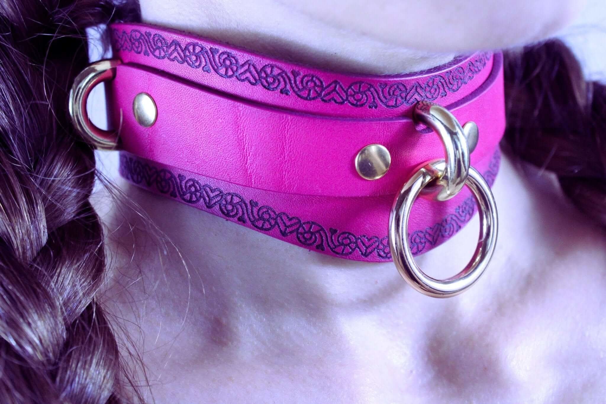 Handcrafted pink submissive collar with heart motif and O-ring for BDSM, bondage, and erotic fashion.