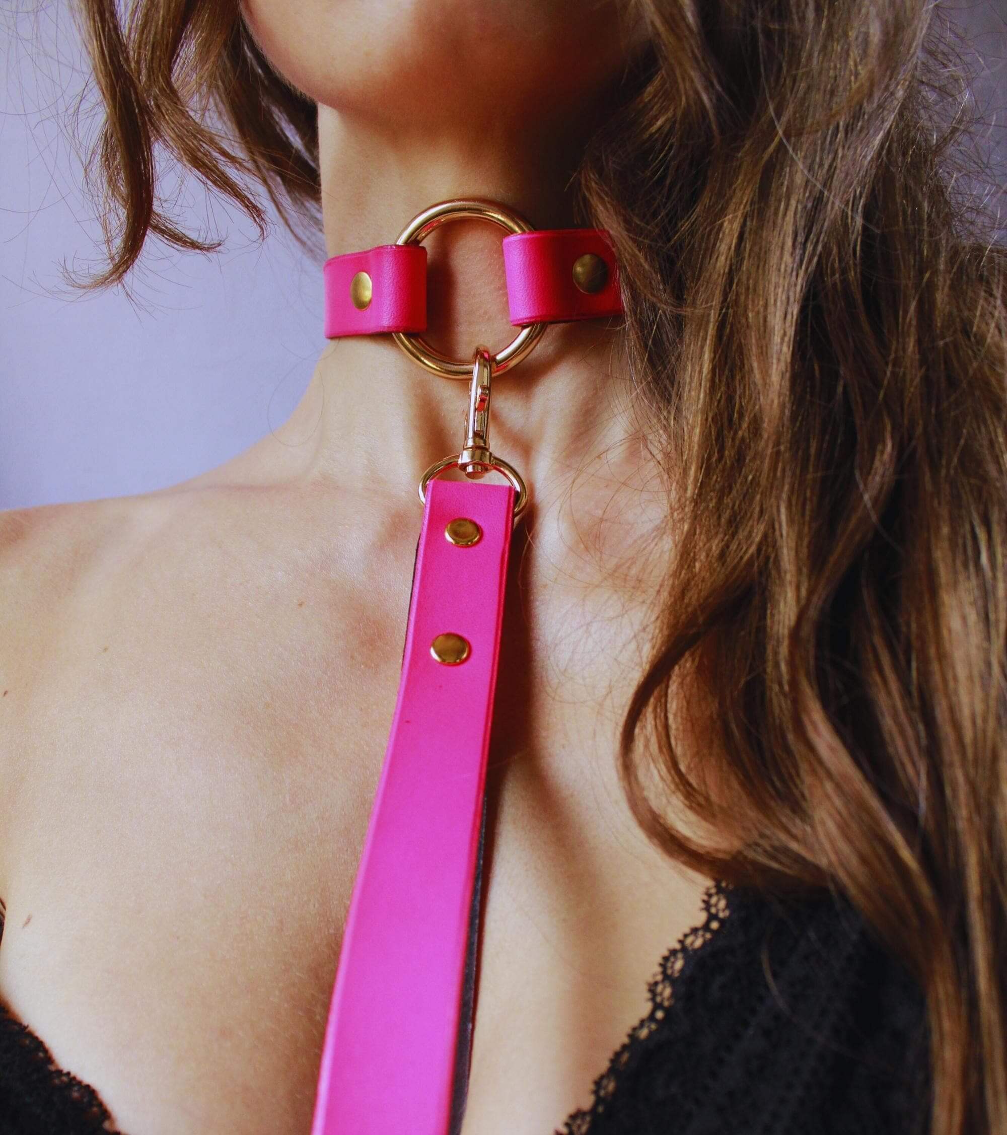 Vibrant neon pink submissive collar with gold-tone hardware, perfect for discreet BDSM day wear and edgy style.