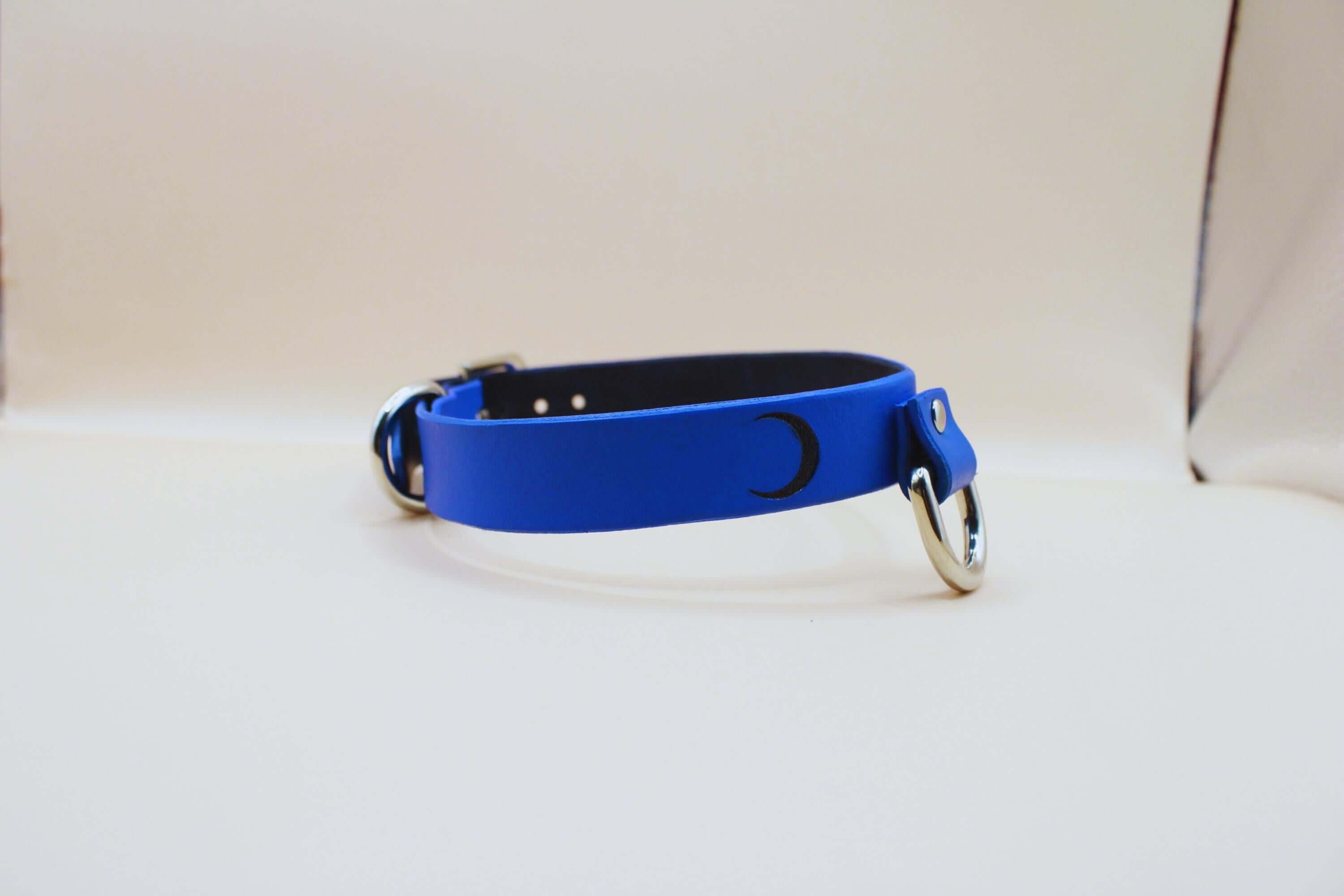 Blue leather submissive collar with crescent moon, perfect for discreet day wear and BDSM jewelry.