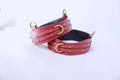 Adjustable leather thigh cuffs in red with gold fittings, perfect BDSM bondage gear for submissives and kink enthusiasts.