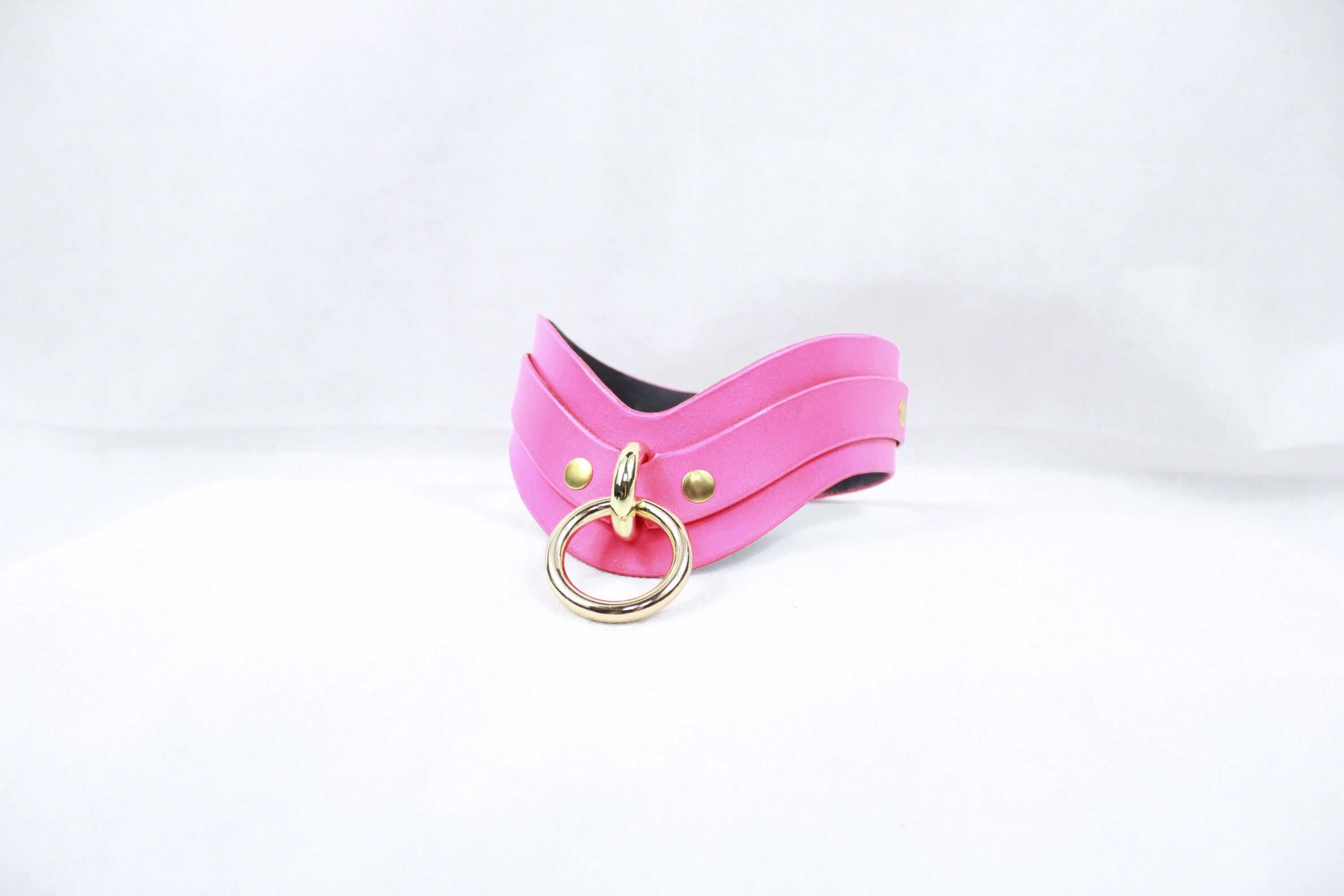 Pink leather BDSM collar with a gold D-ring, perfect for submissive jewelry and discreet day collar wear.