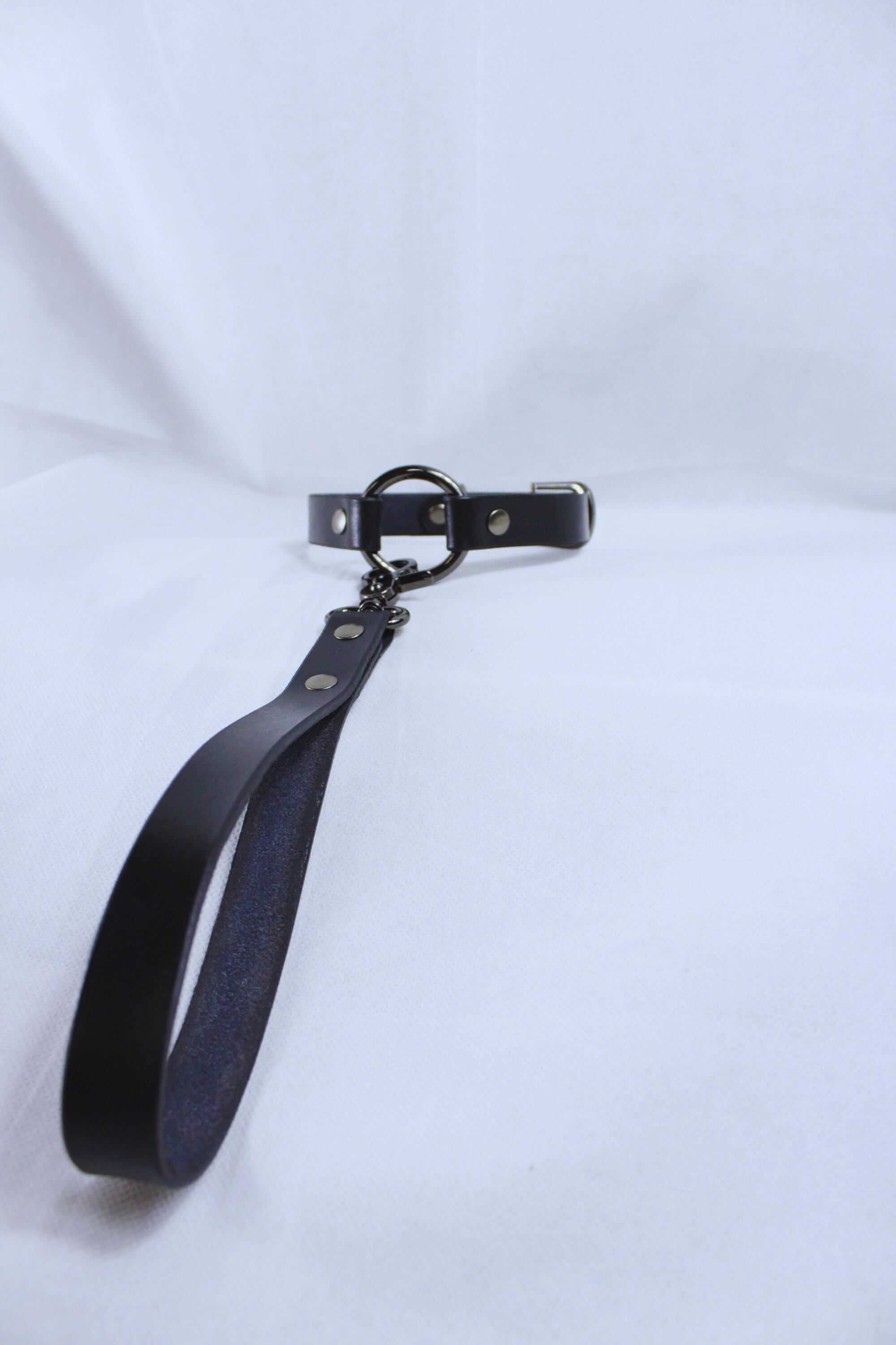 Leather BDSM collar with metal leash attachment, perfect for submissive day wear or intimate play.
