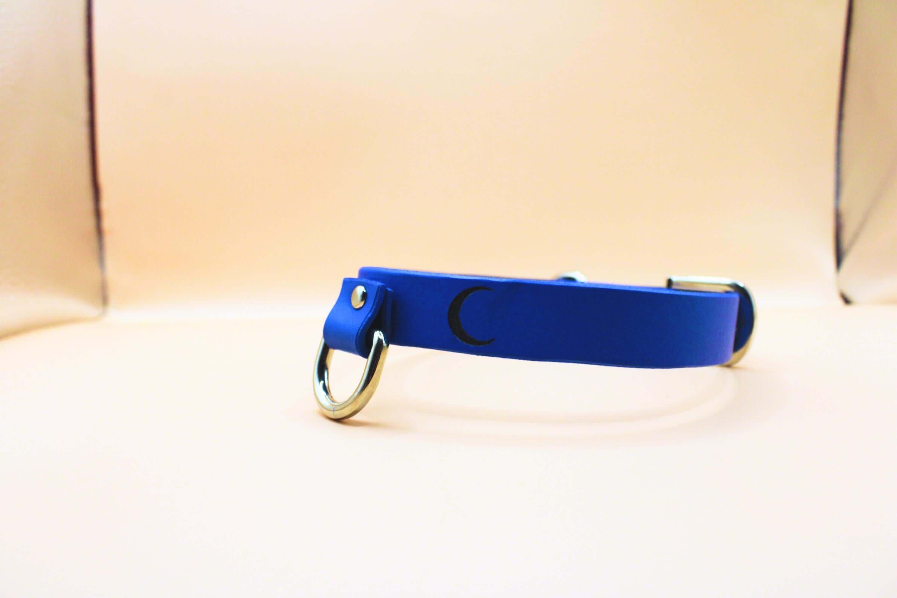 Blue leather submissive collar with crescent moon design, perfect for discreet day wear and BDSM jewelry.