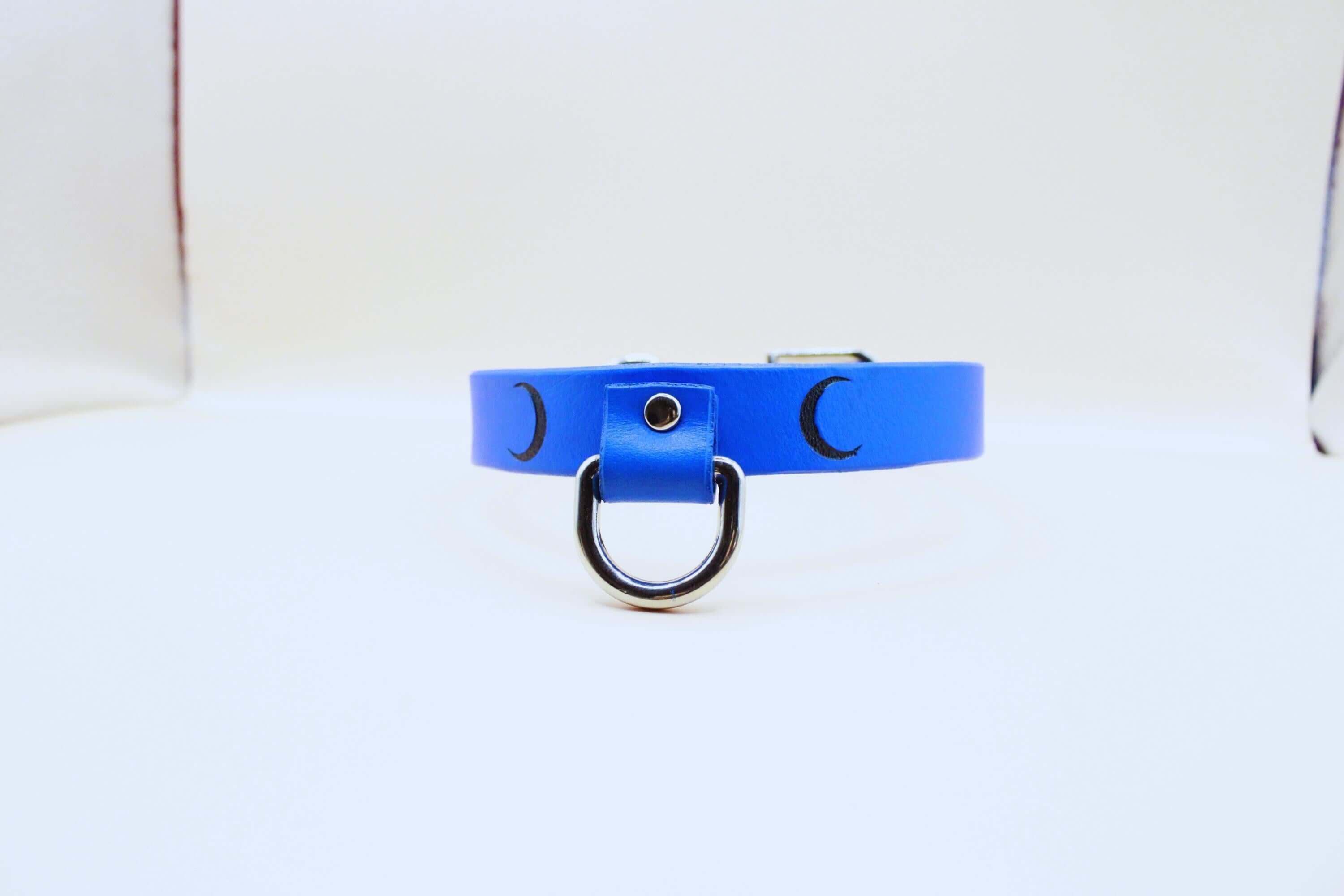 Blue leather choker with crescent moons, a discreet day collar for submissive jewelry and BDSM gifts.