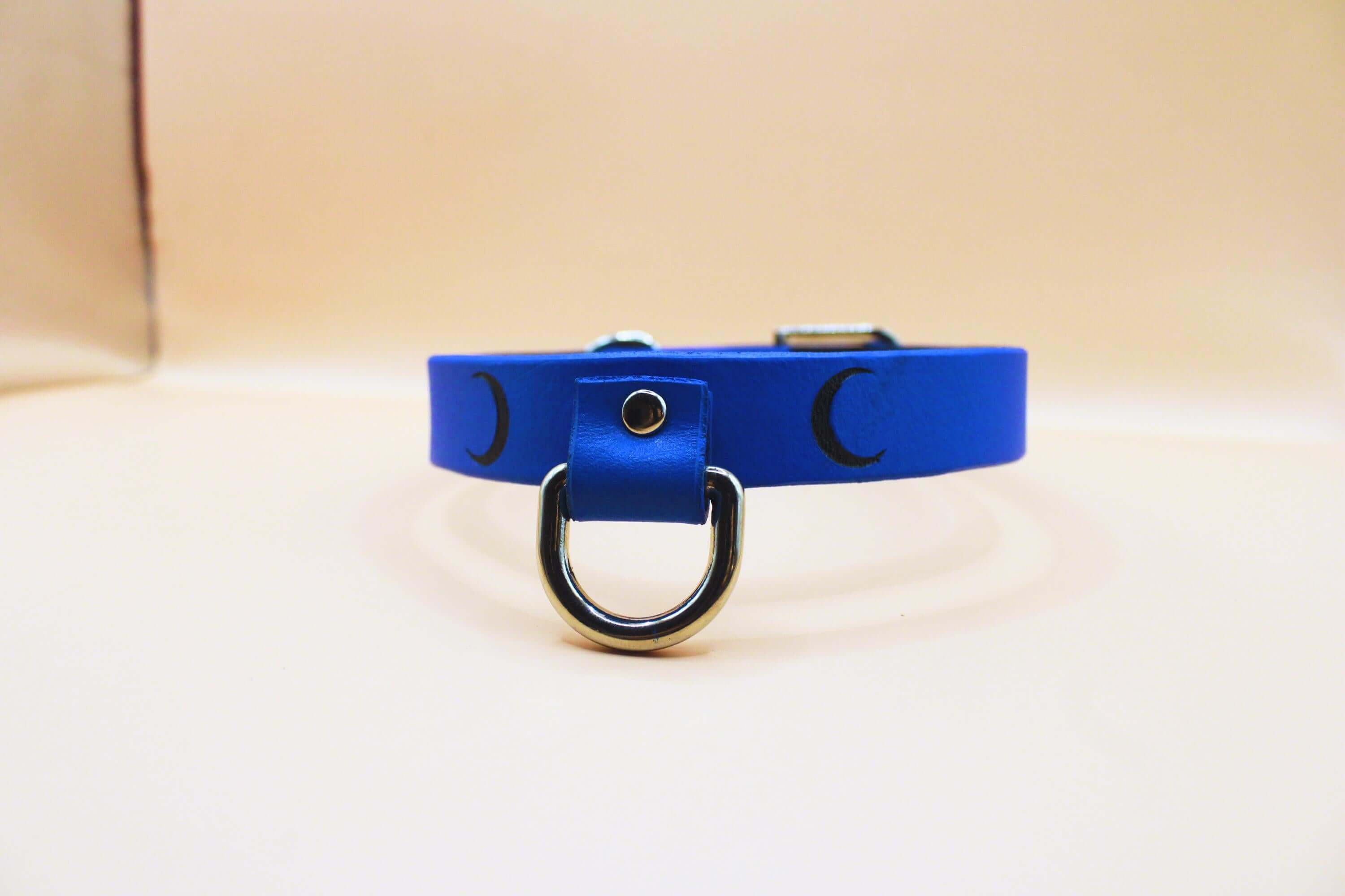Blue leather submissive collar with crescent moon design, perfect for discreet day wear and BDSM jewelry.