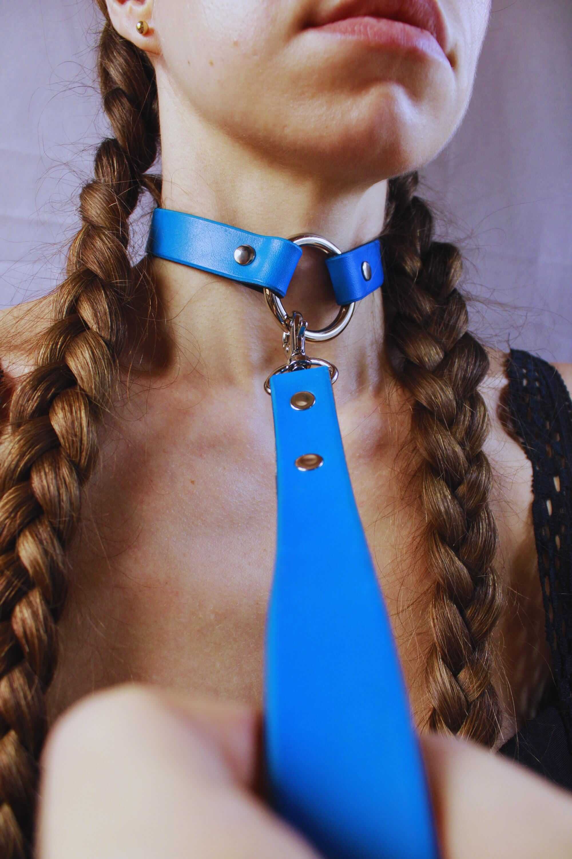 Blue BDSM leash attached to a submission collar, ideal for bondage gear and submissive play.