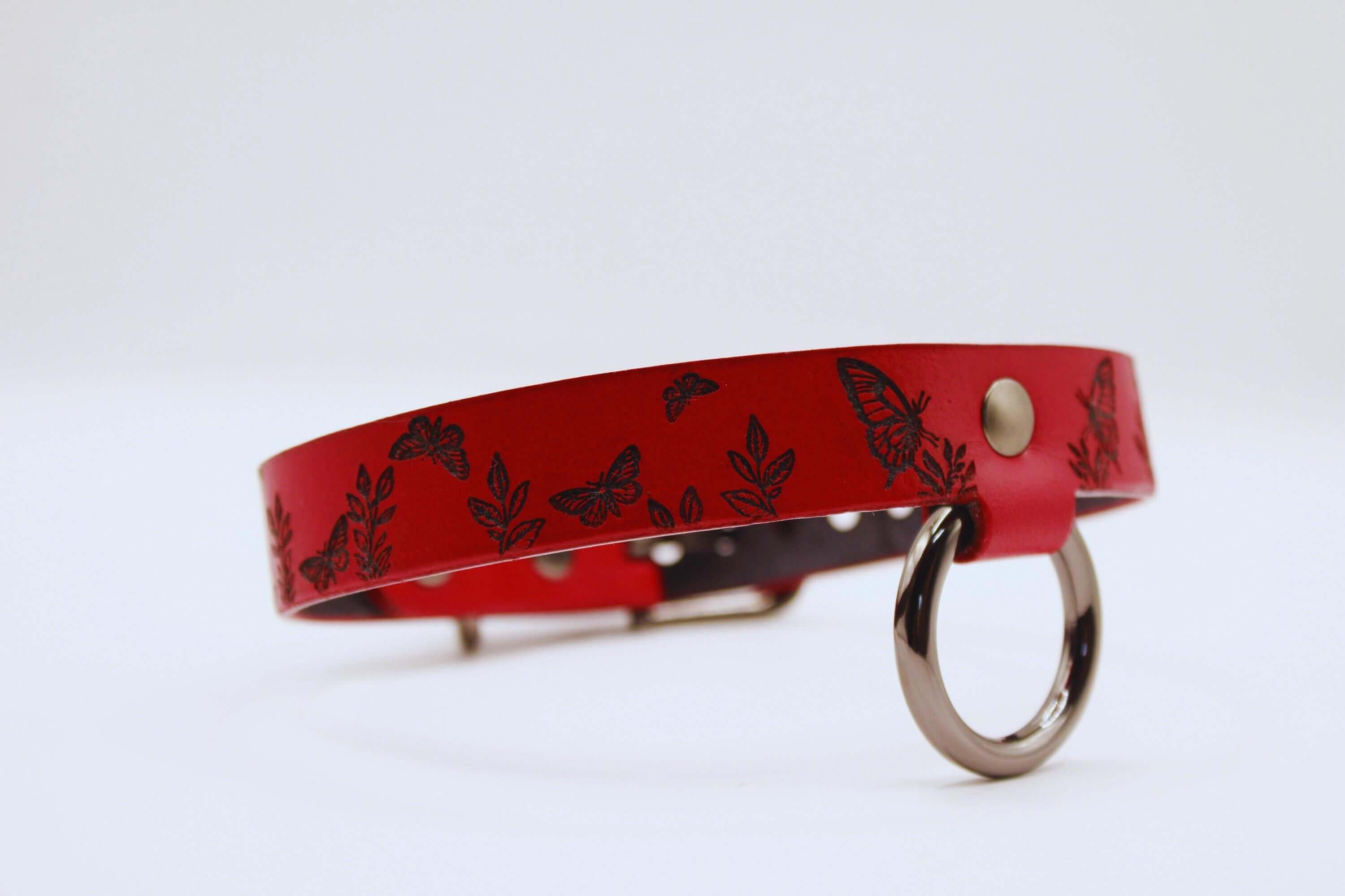 Deep red leather submissive collar with butterfly designs, ideal for BDSM and modern submissives.
