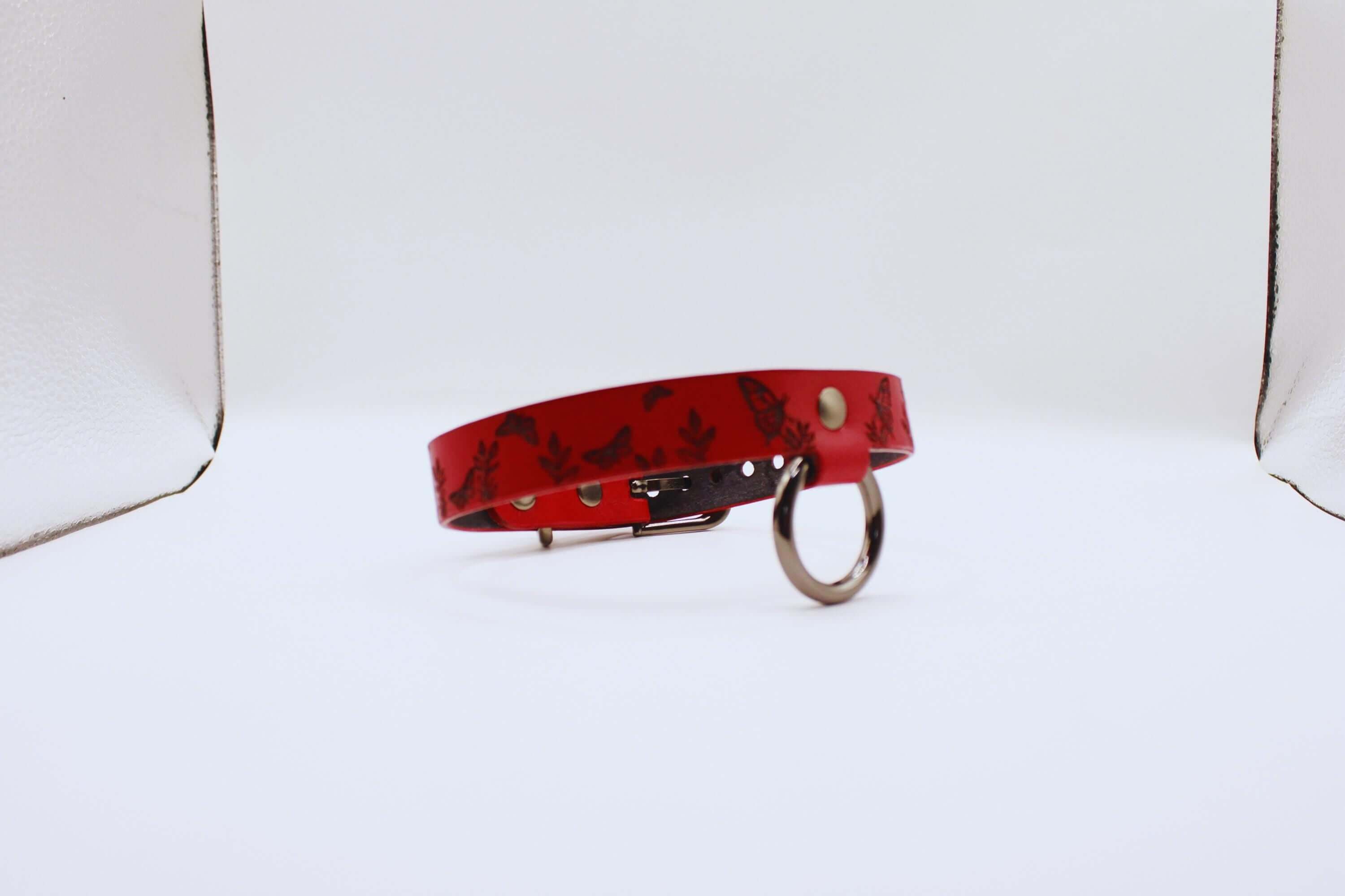 Handmade Submissive Collar in deep red leather with butterfly designs, perfect for BDSM and discreet day wear.