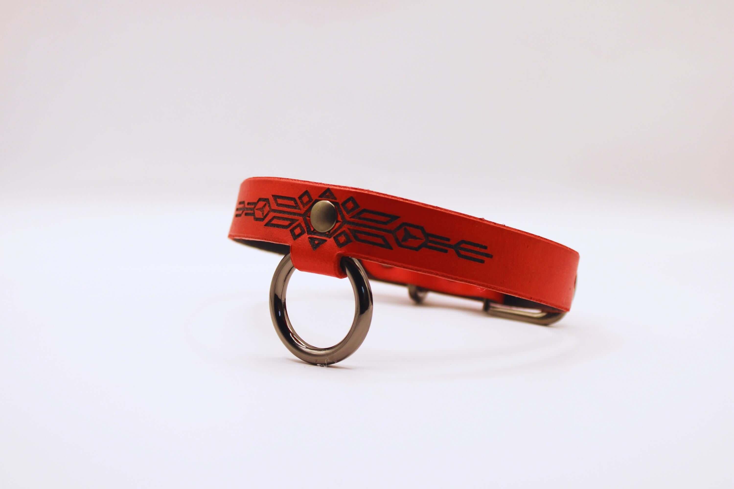 Handmade submissive collar of fire in red leather with black geometric patterns, perfect for discreet BDSM and submissive jewelry.