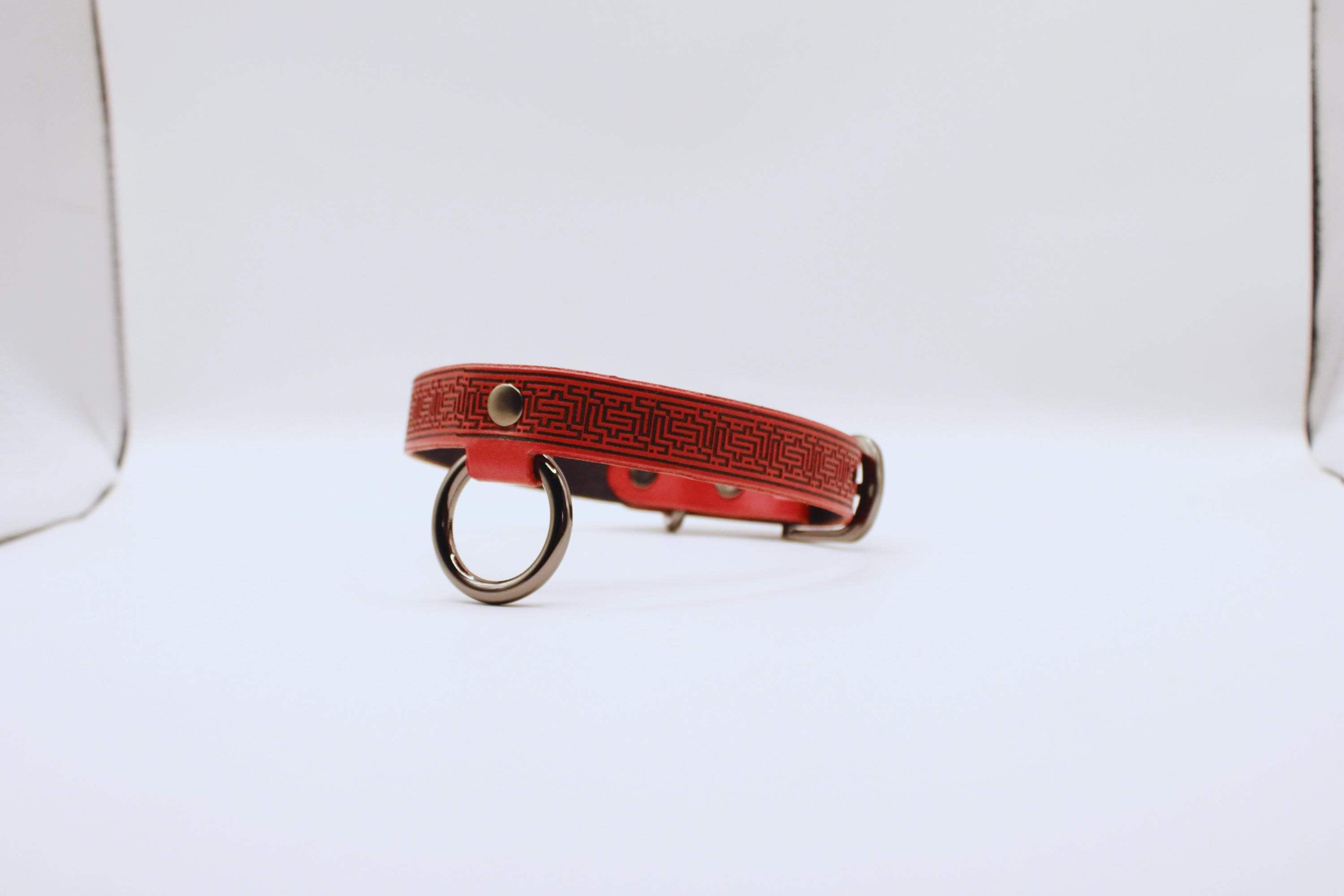 Red leather BDSM collar with intricate design, ideal for submissive wear and daily elegance.