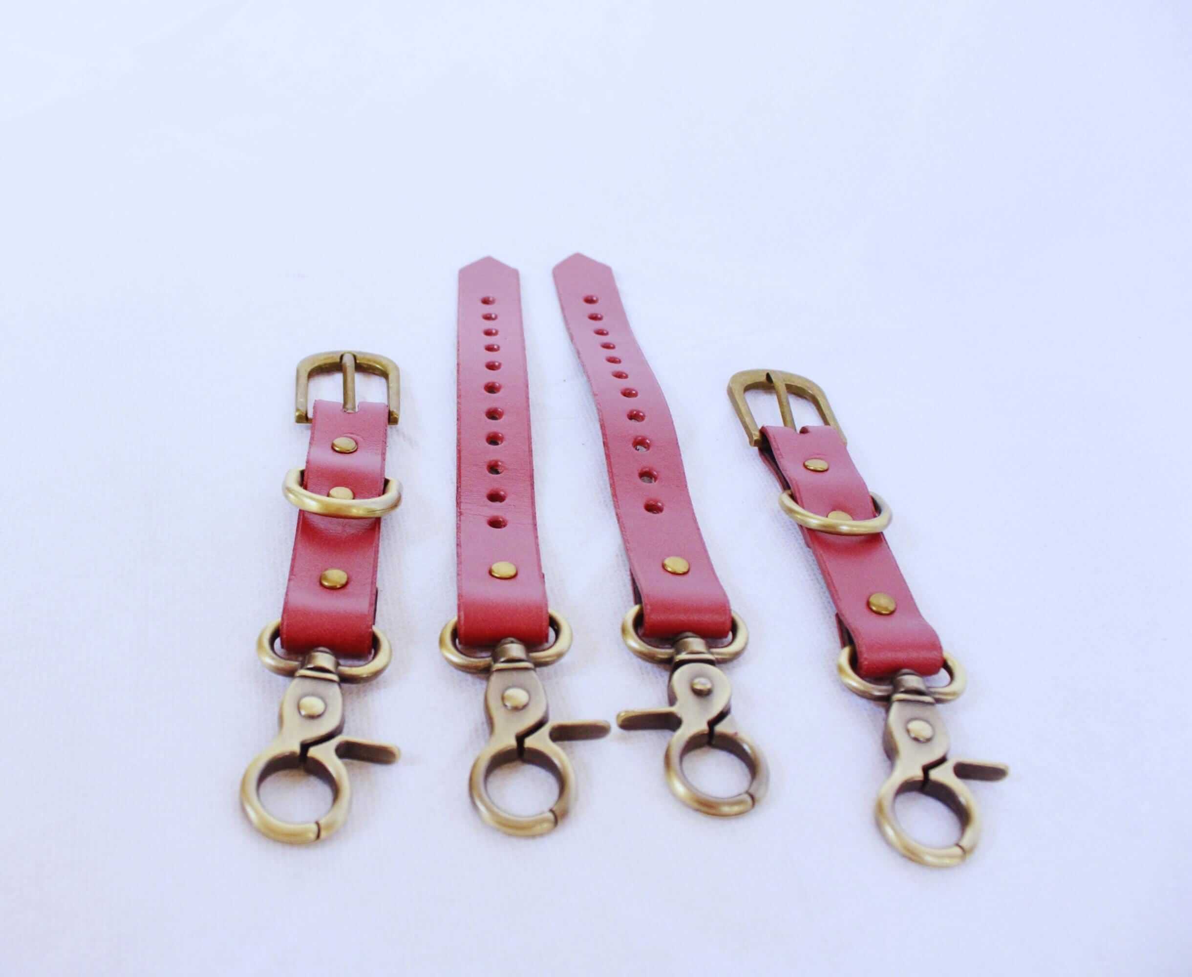 Adjustable BDSM Connector – handmade leather restraint straps with brass hardware in pink.