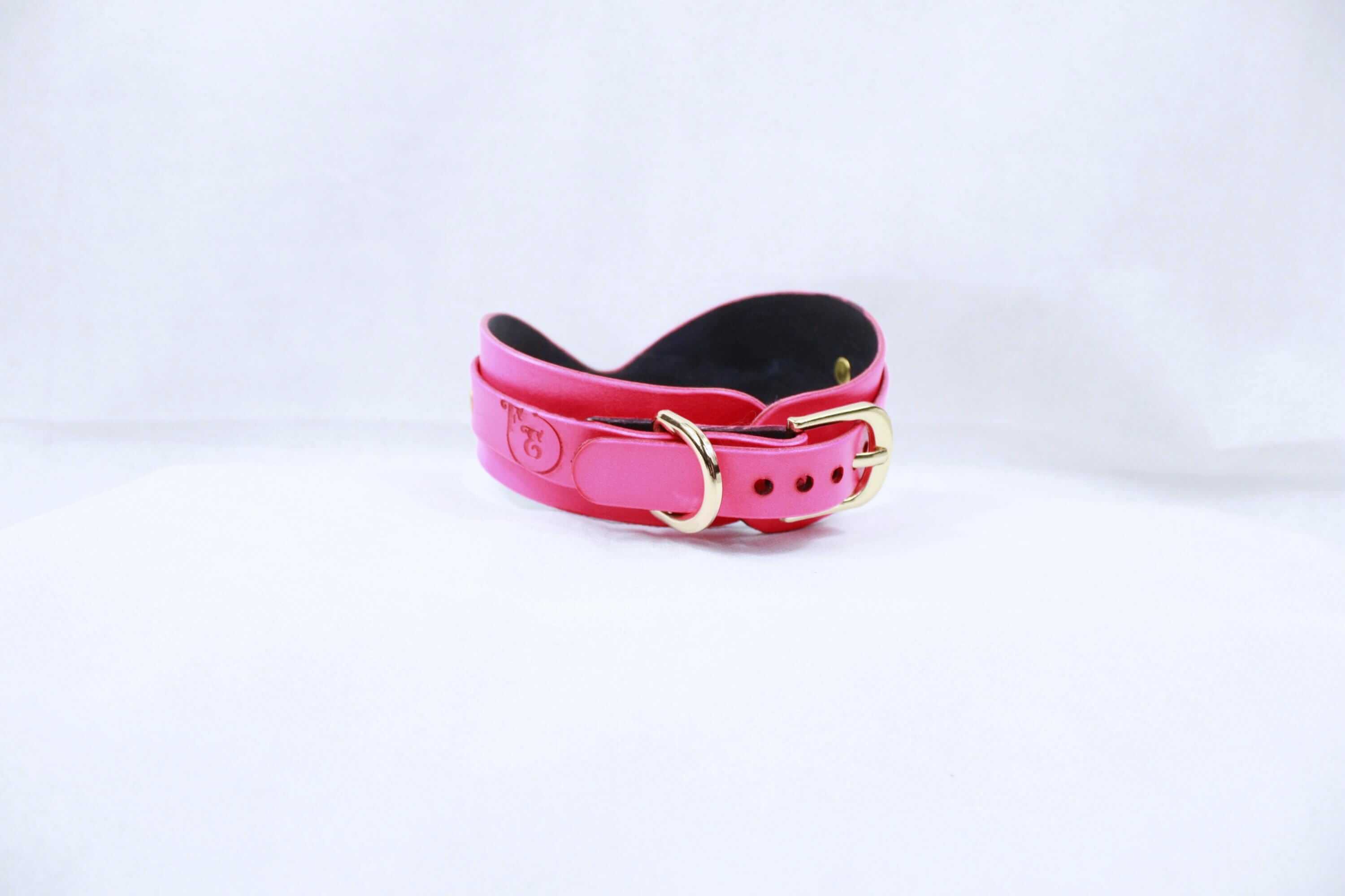Elegant pink leather BDSM collar with gold hardware, perfect for discreet submissive wear and stylish bondage gear.