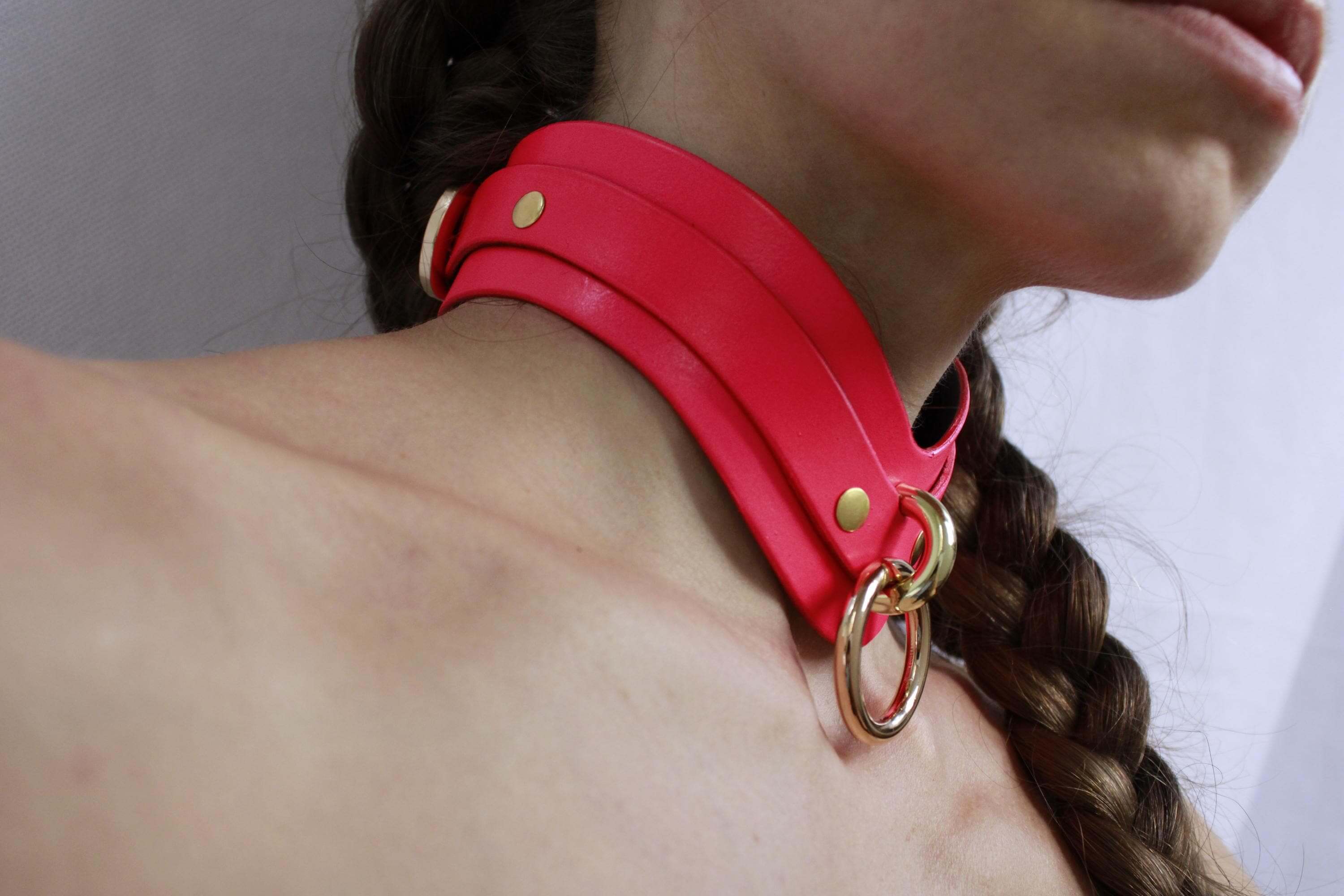 Pink leather submissive collar with gold accents, ideal for discreet day wear or BDSM play, perfect for bondage enthusiasts.