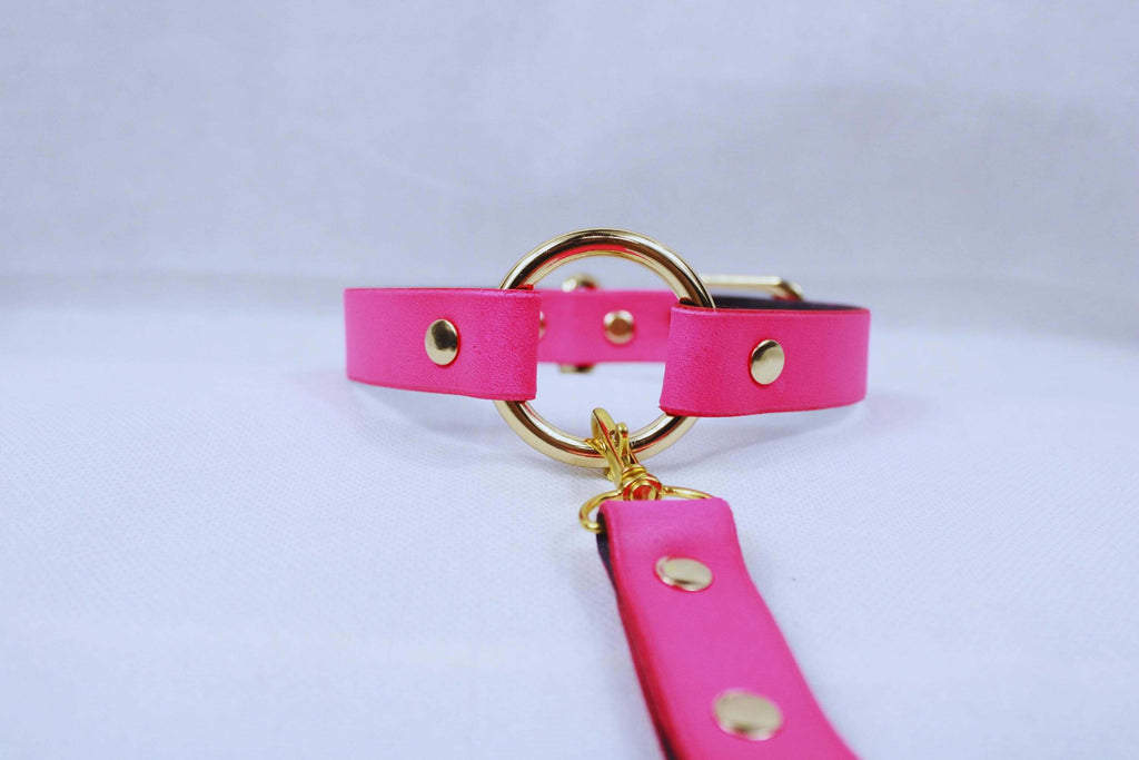 Bdsm collar in vibrant pink with gold hardware, perfect for submissive play and discreet day wear.