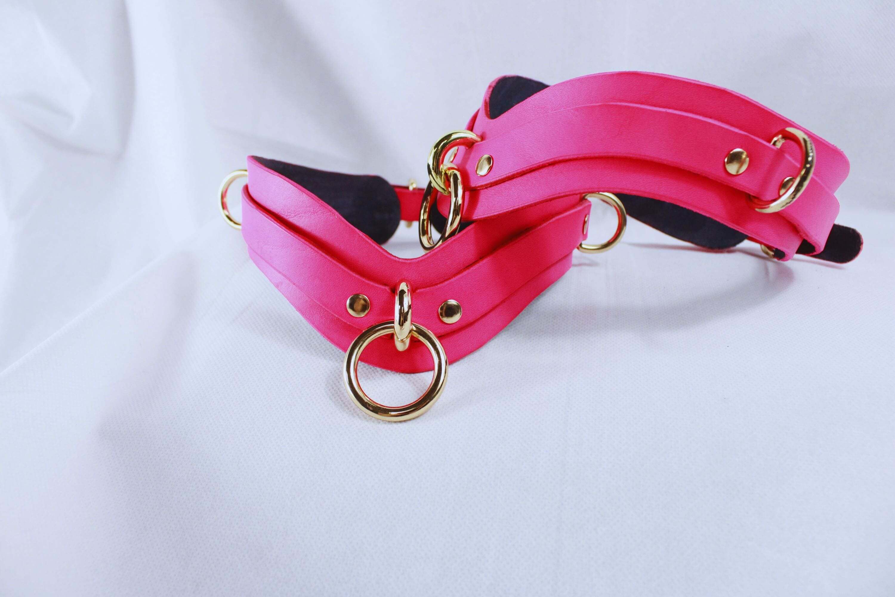 Bondage Gear Pink Thigh Cuffs with gold-tone hardware, ideal for BDSM and couples' intimate adventures.