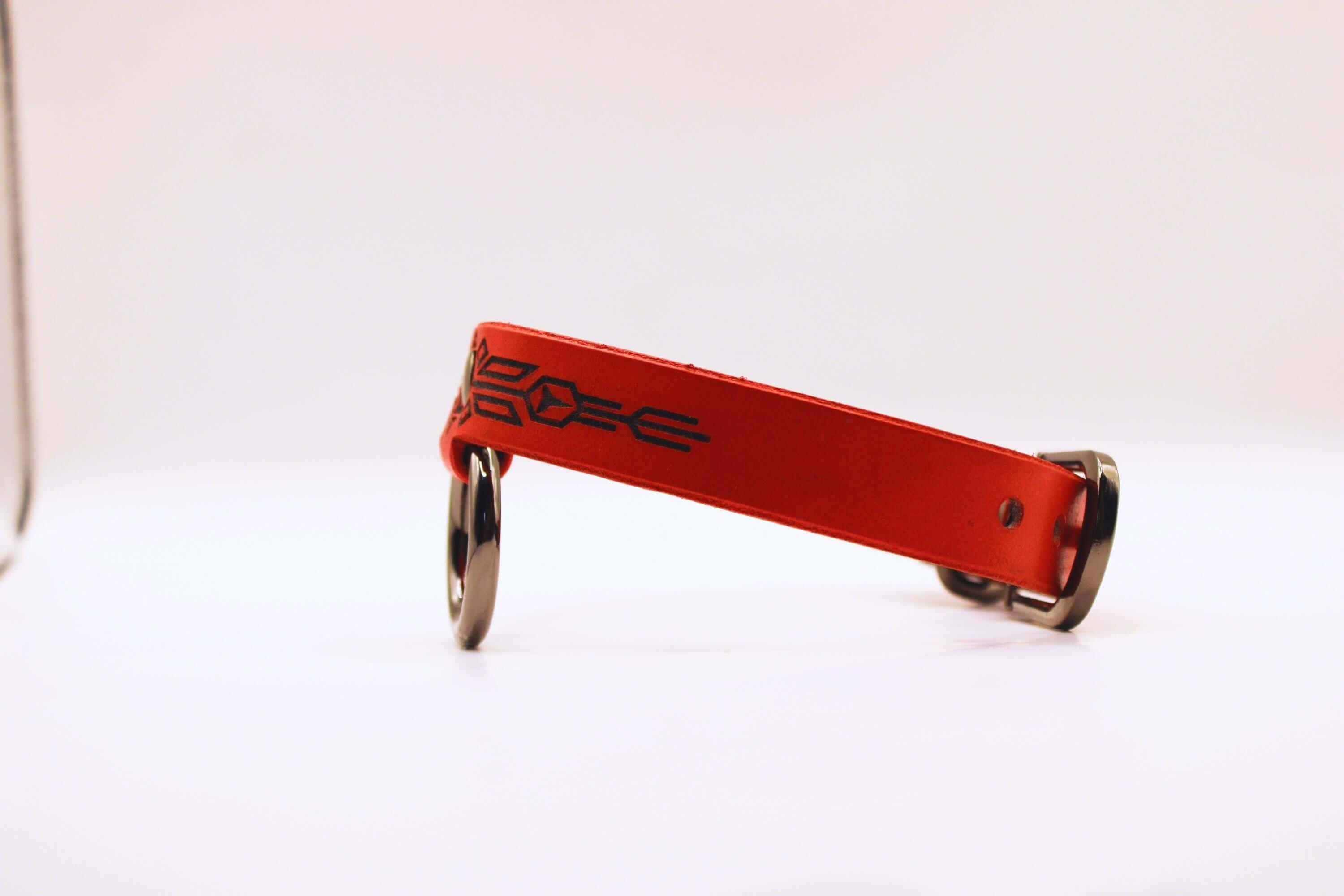 Submissive collar of fire in red leather with black geometric patterns, perfect for BDSM enthusiasts.