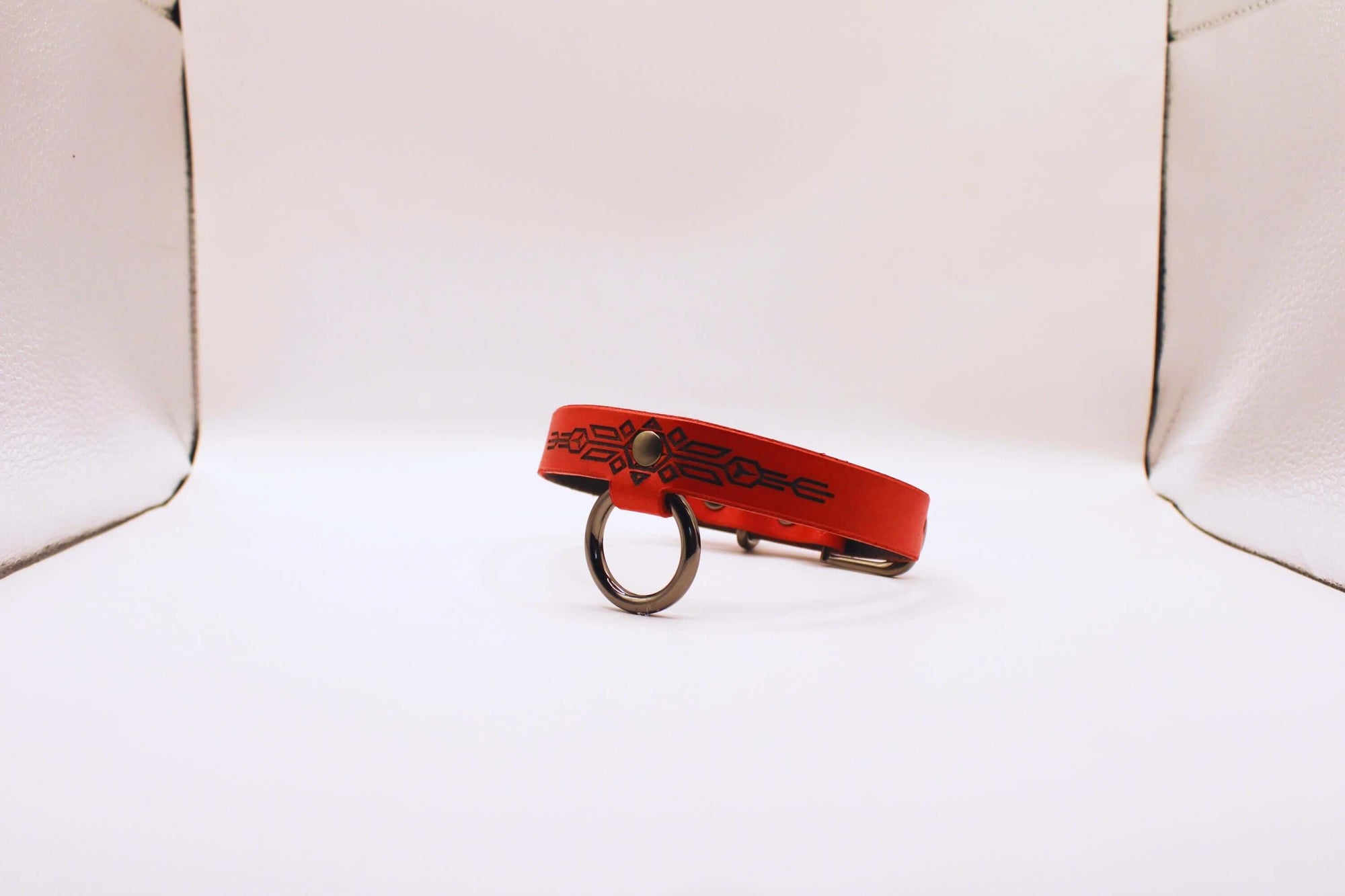 Submissive collar of fire in red leather, featuring geometric patterns. Ideal BDSM collar for confident wear.
