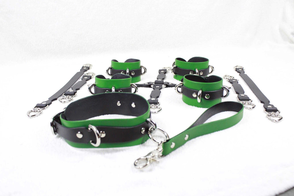 A collection of green and black leather straps and buckles arranged on a white surface.