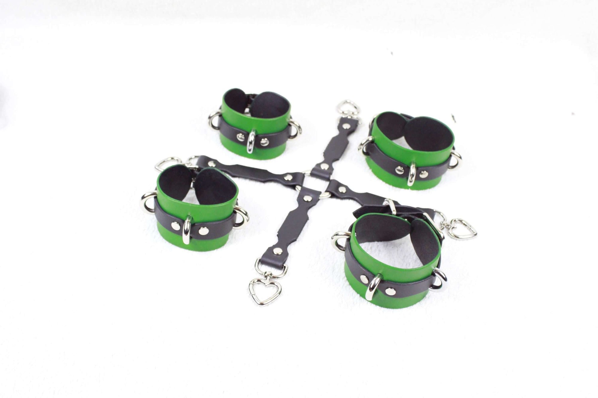 a collection of green and black leather straps or cuffs arranged in a circular pattern on a white background.