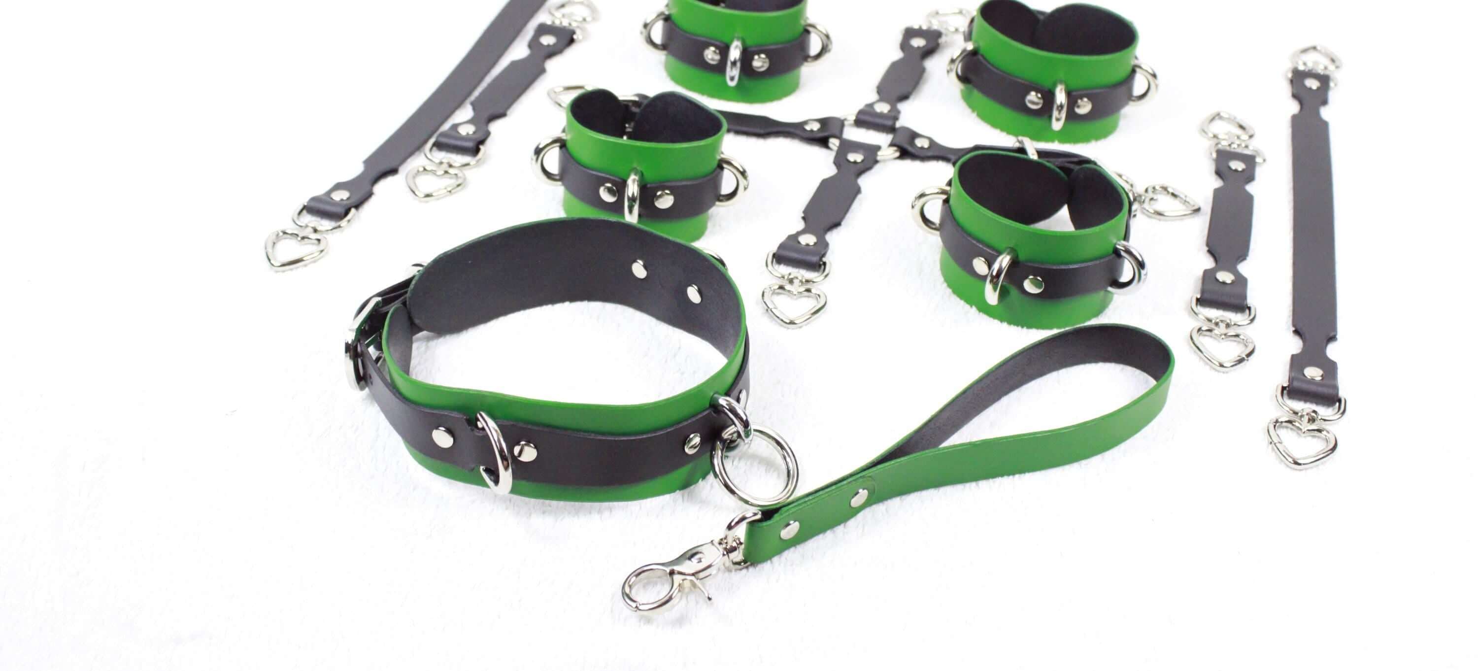 a collection of green and black leather restraints and straps, likely used for BDSM or BDSM-related activities.