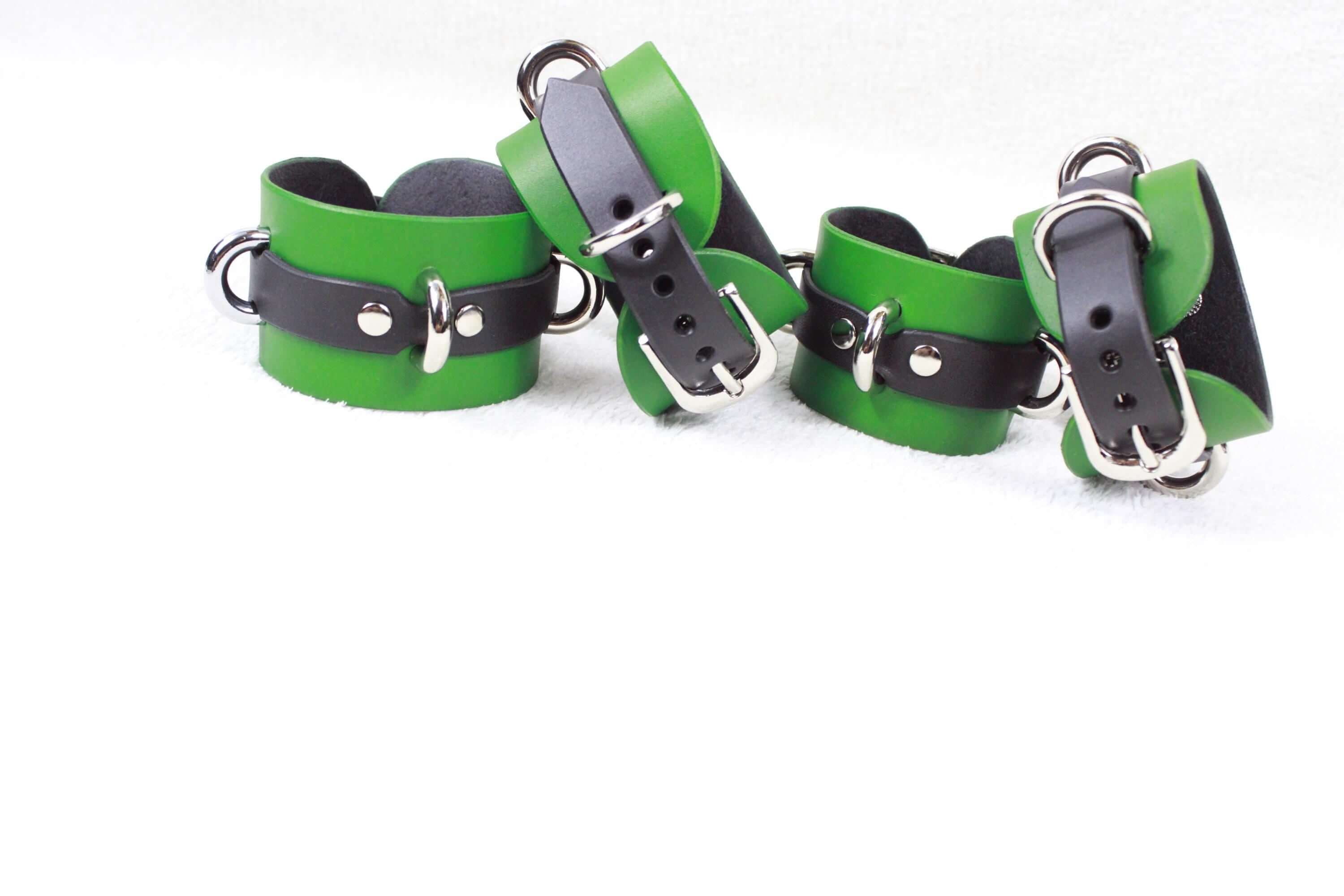 A group of green leather wristbands with black metal buckles, arranged on a white background.