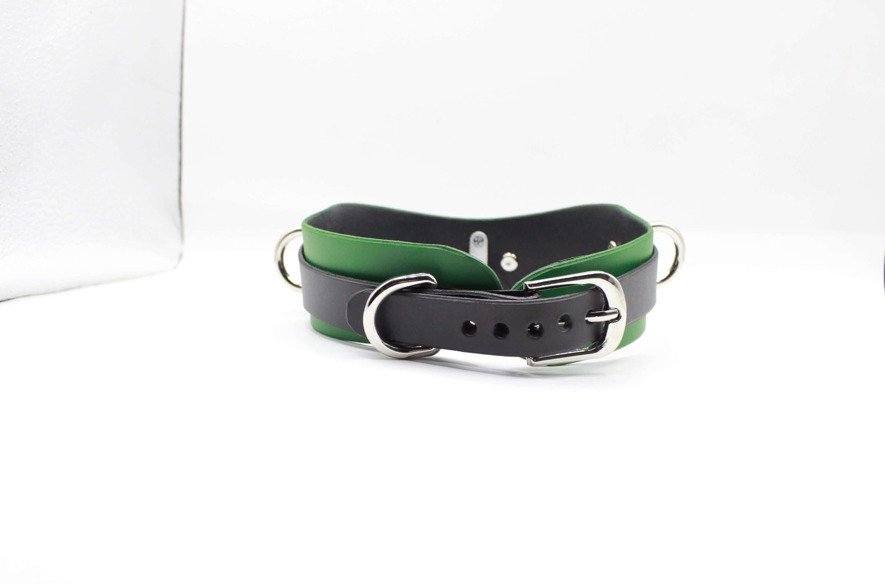 A green and black leather collar with a silver buckle is shown against a white background.