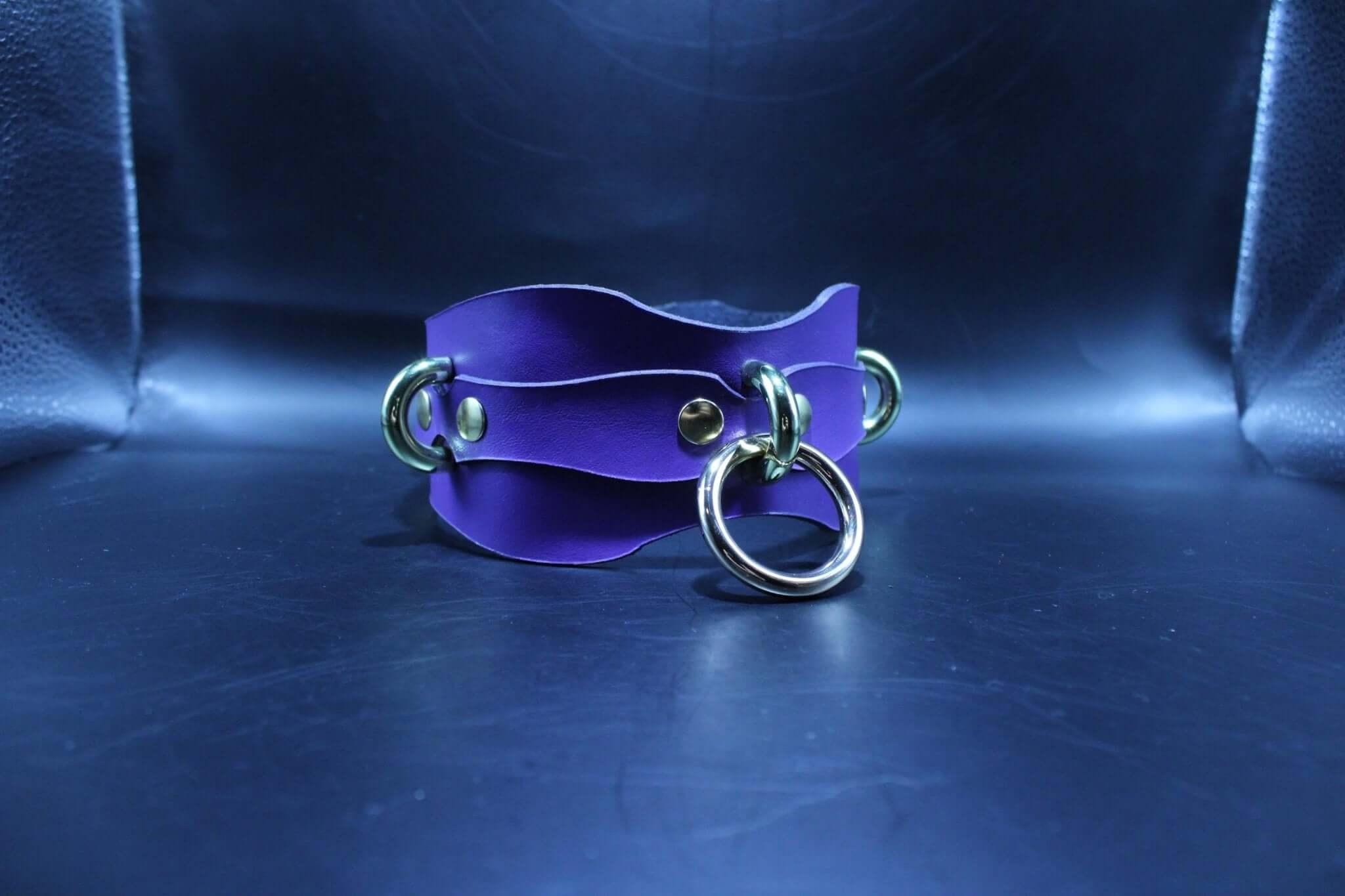 Purple leather submissive collar with O-ring for BDSM play, adjustable and comfortable for bondage scenes.