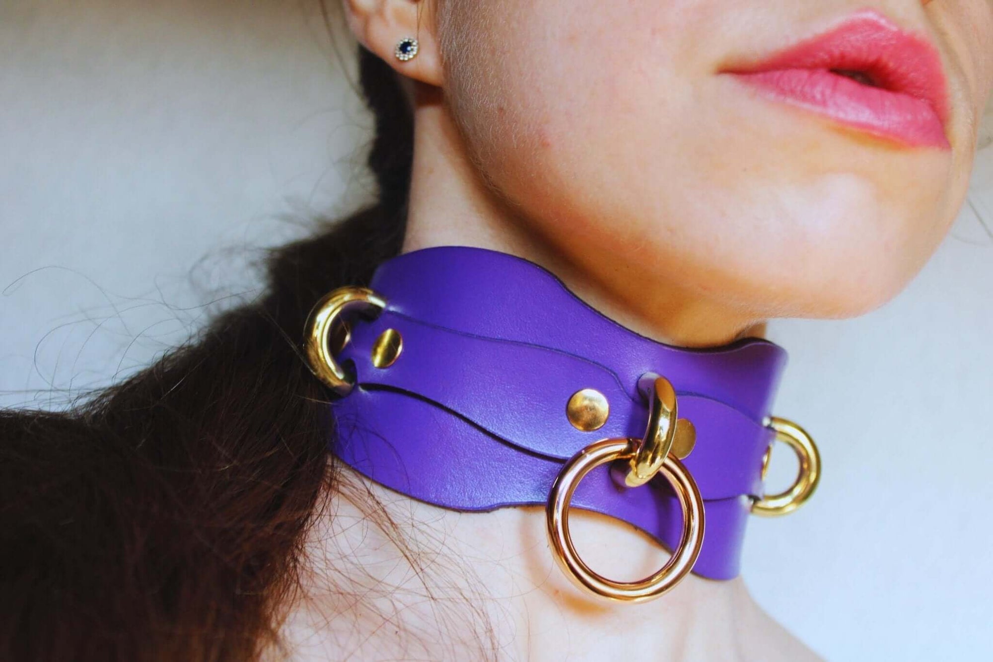 Purple leather submissive collar with O-rings, perfect for BDSM play and discreet day wear. Adjustable design for comfort.