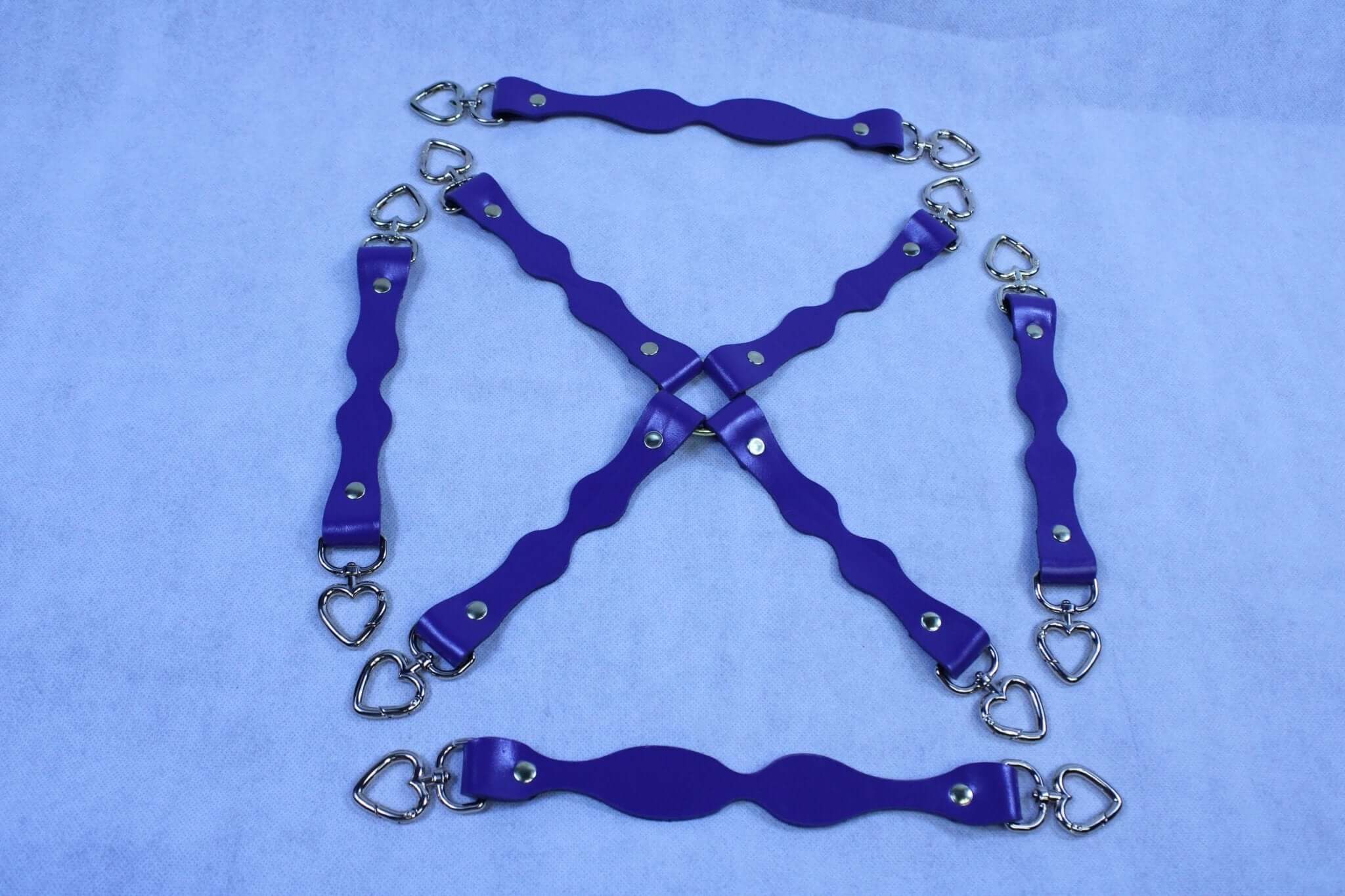 Handmade purple leather BDSM connectors with D-ring attachments for bondage gear and restraint accessories.