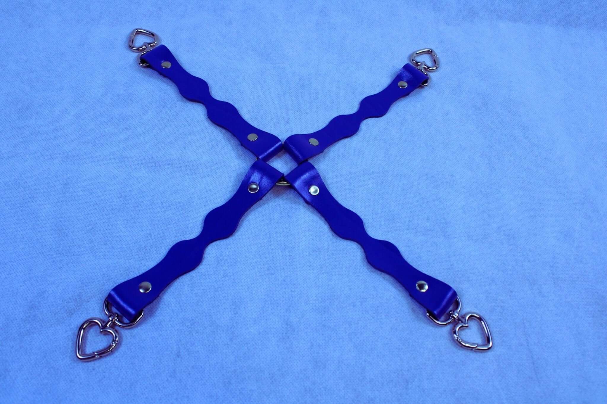 Handmade leather BDSM connectors with heart-shaped D-ring attachments for bondage gear.