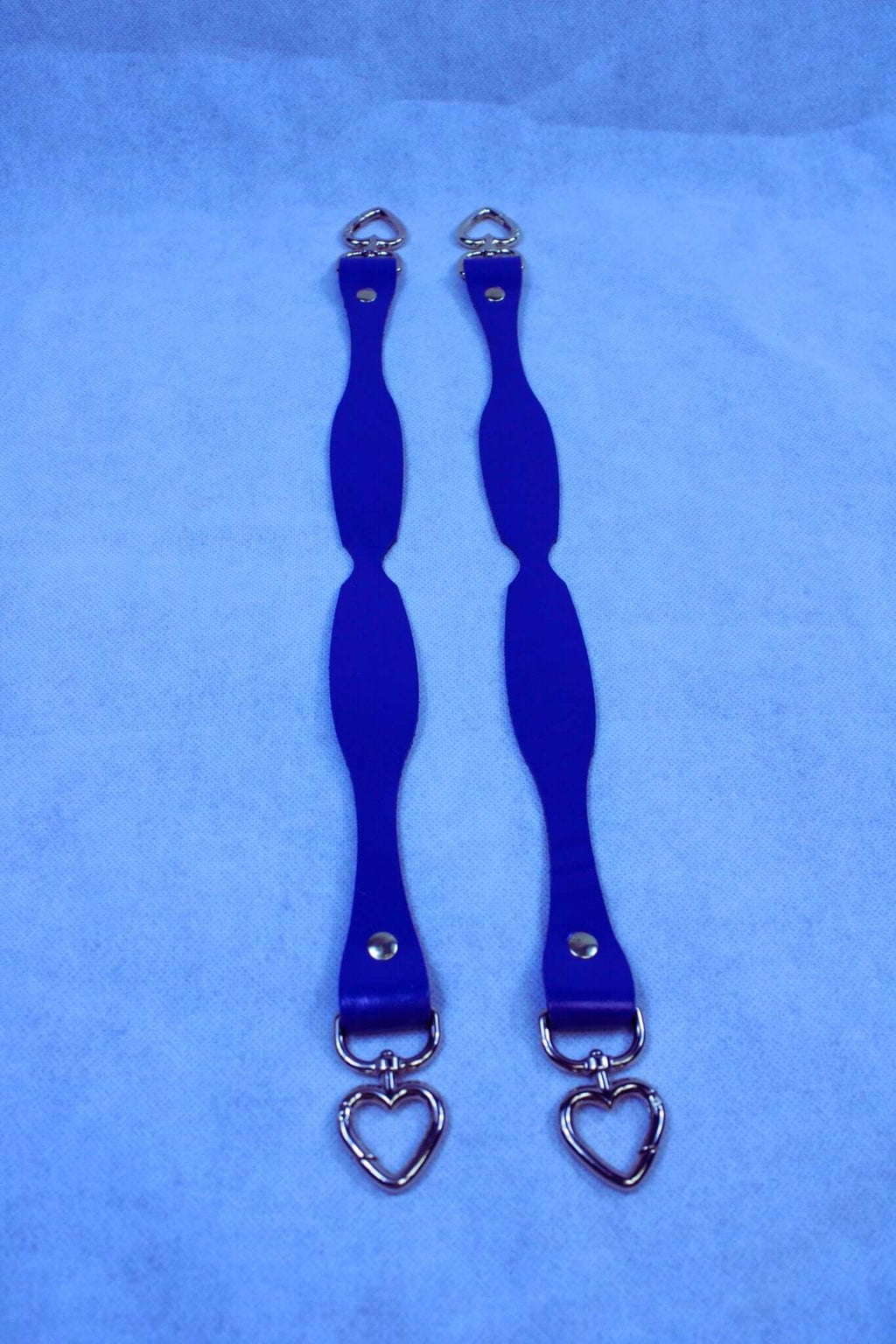 Handmade blue leather connectors with heart D-ring attachments, perfect for BDSM gear and bondage accessories.