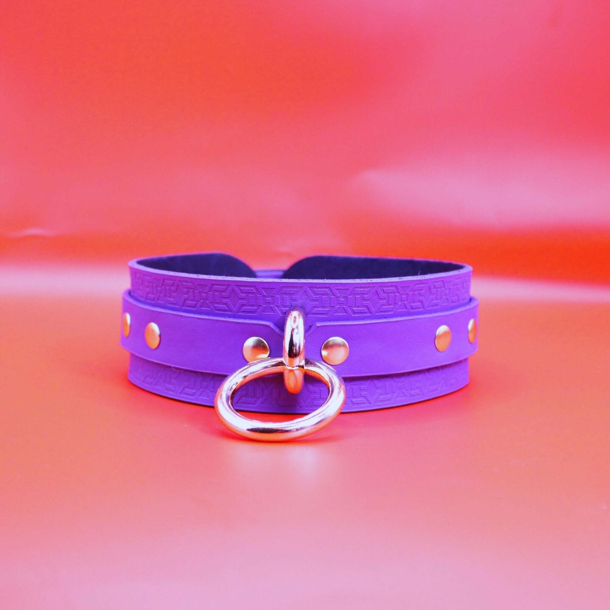 Vibrant violet leather choker collar with gold hardware, perfect for BDSM and discreet day wear.