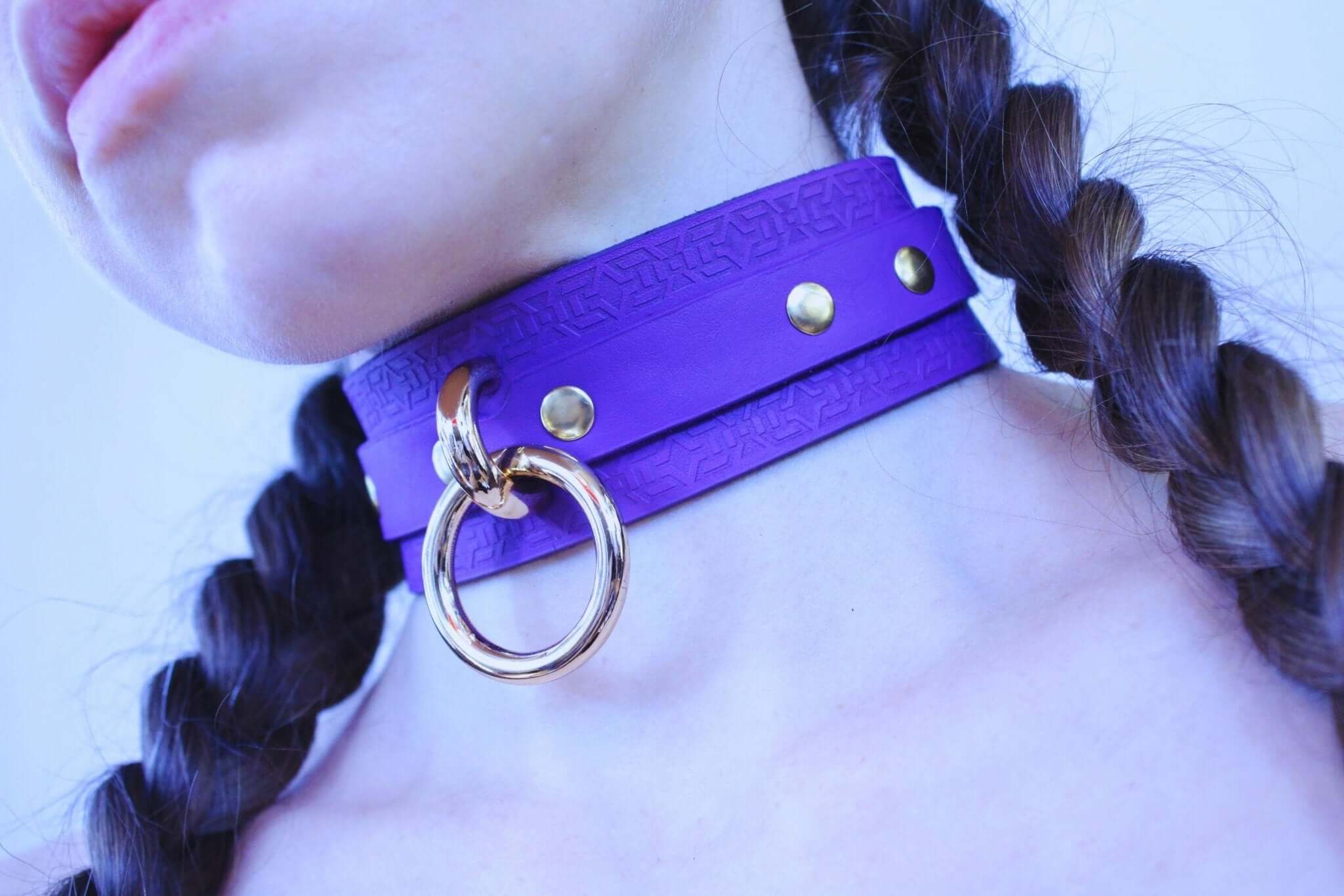Vibrant violet leather choker collar with gold hardware, perfect for submissive jewelry and discreet day wear in BDSM.