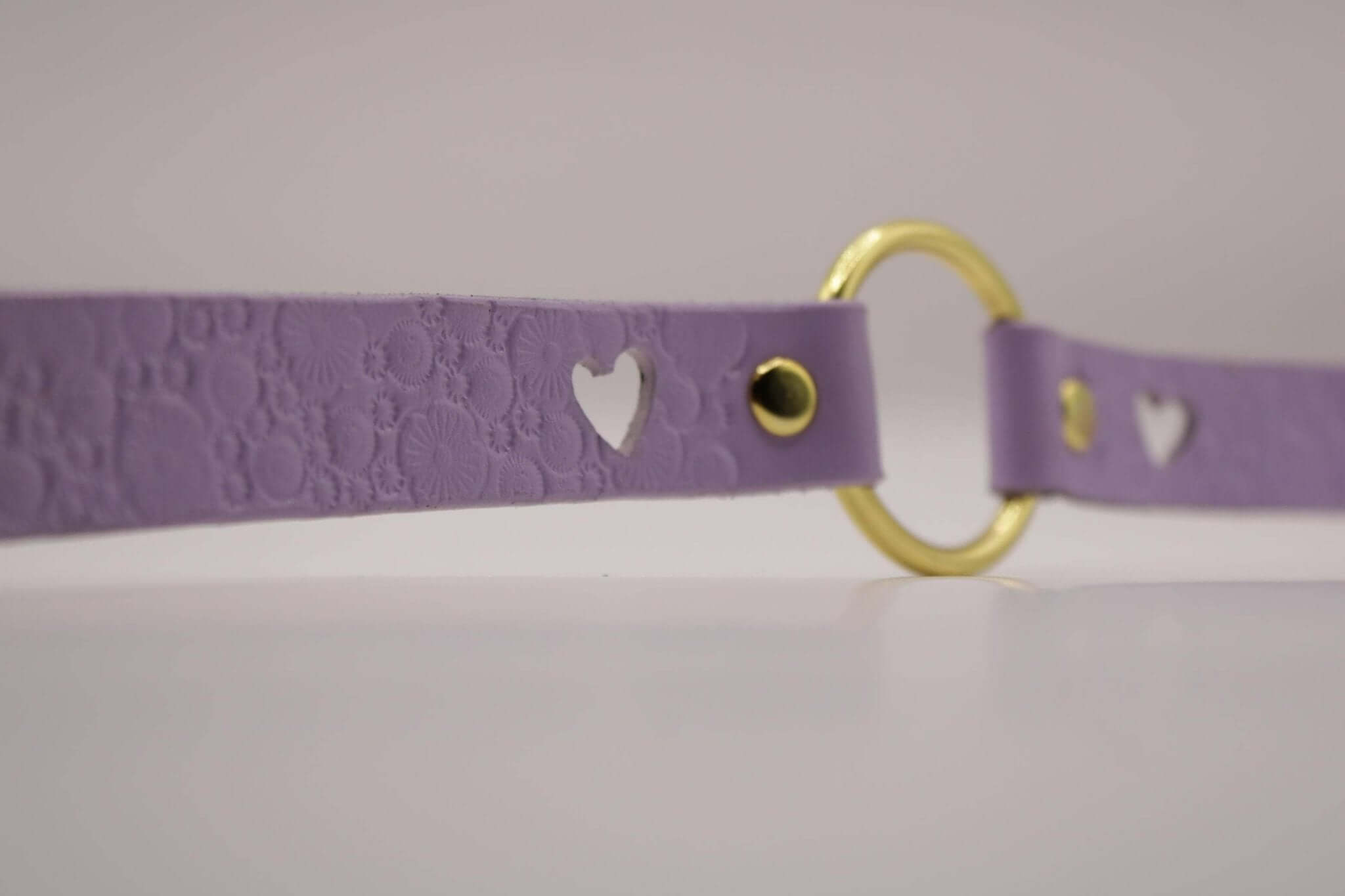 Lilac submissive collar with heart cutouts, a delicate BDSM accessory for bondage and submissive jewelry.