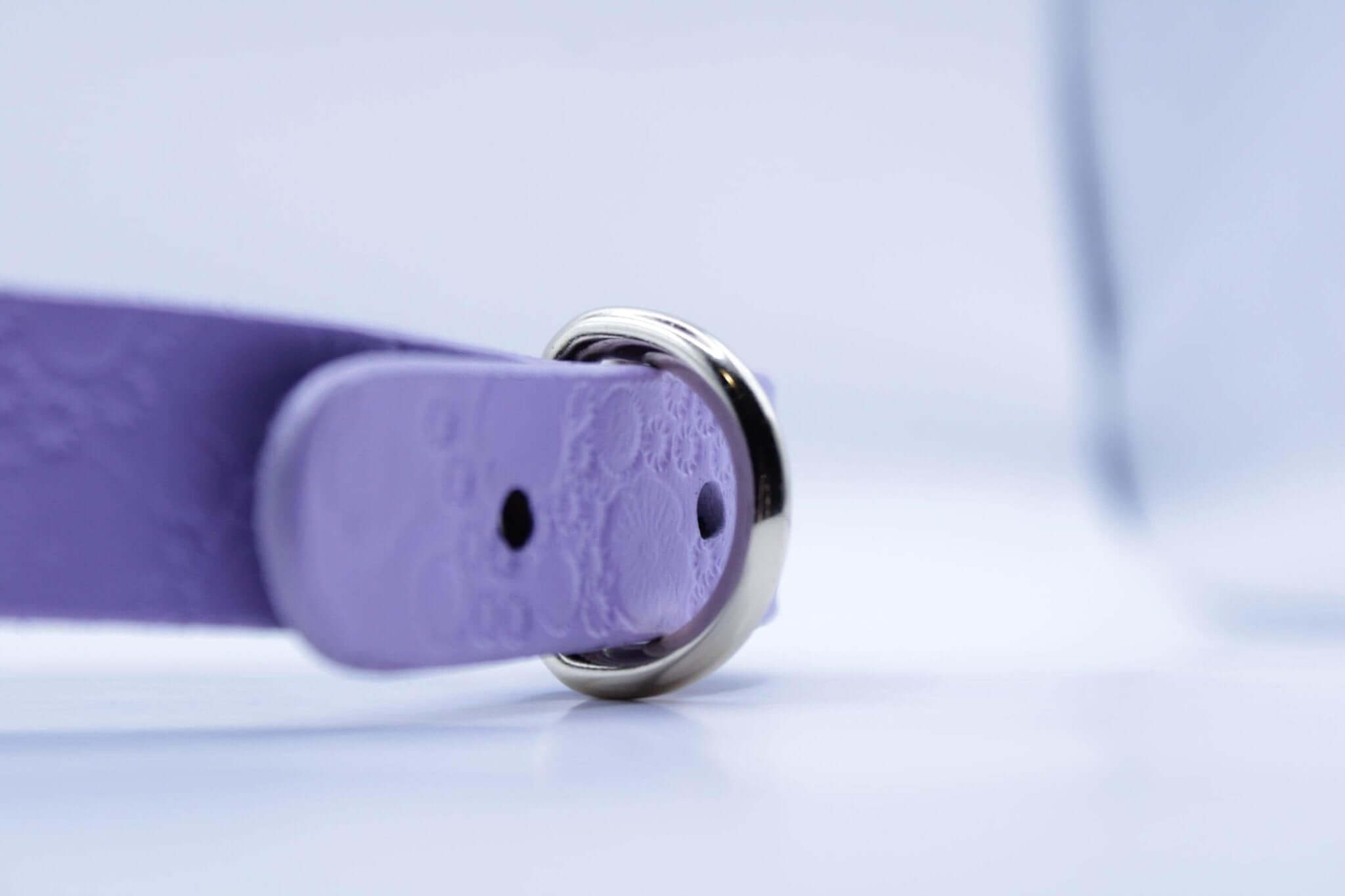 Close-up of a lilac leather submissive collar with heart cutout detail and metallic ring, ideal for BDSM and bondage accessories.