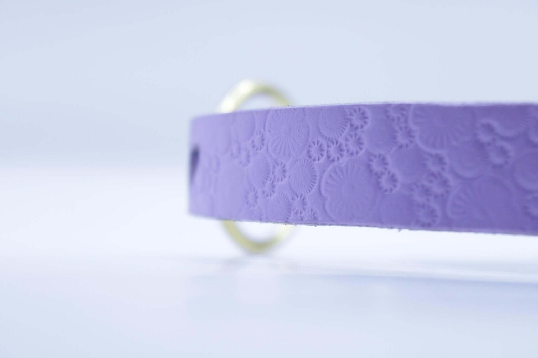 Close-up of a lilac leather submissive collar with floral texture, perfect for BDSM and stealthy day wear.