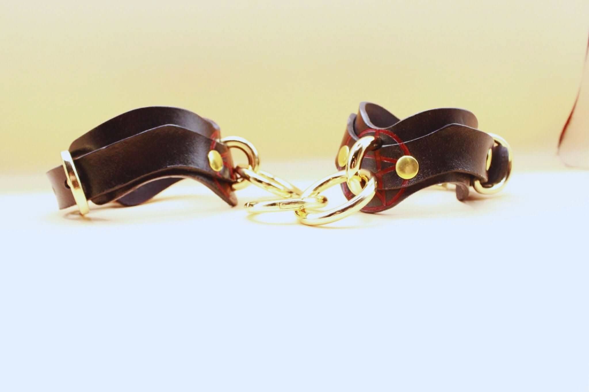 Luxury leather BDSM cuffs with gold hardware for bondage play, perfect for submissives and kinksters.