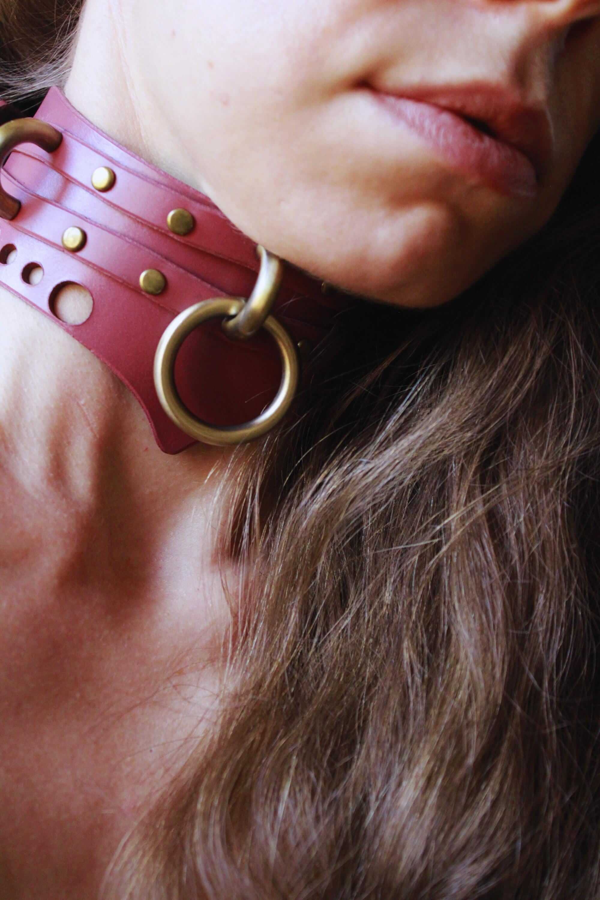 Close-up of a mauve leather choker, a stylish submissive collar with metal accents, perfect for BDSM and discreet day wear.