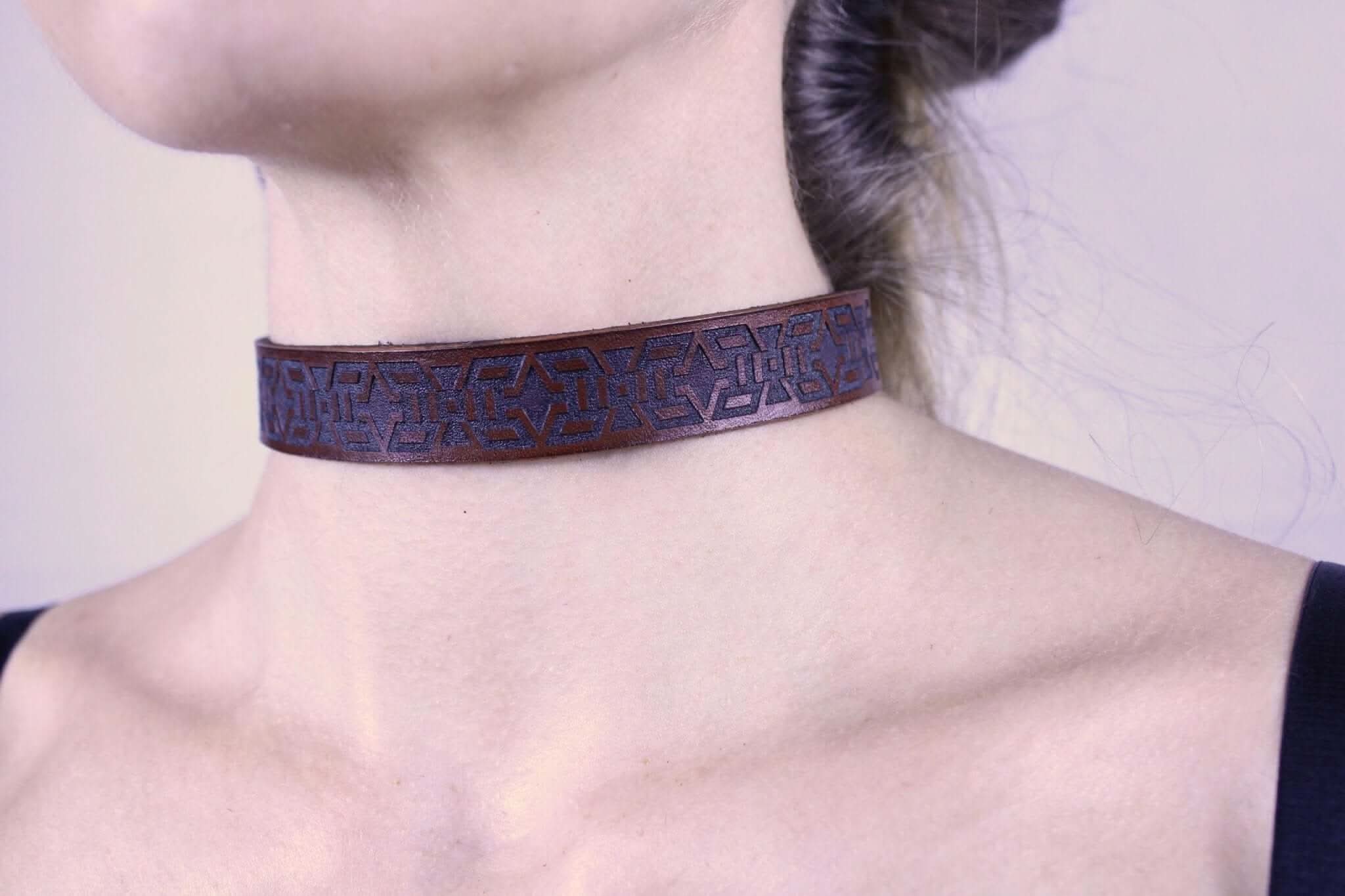 Minimalist leather BDSM collar with tribal motif, perfect for discreet wear as a submissive day collar.