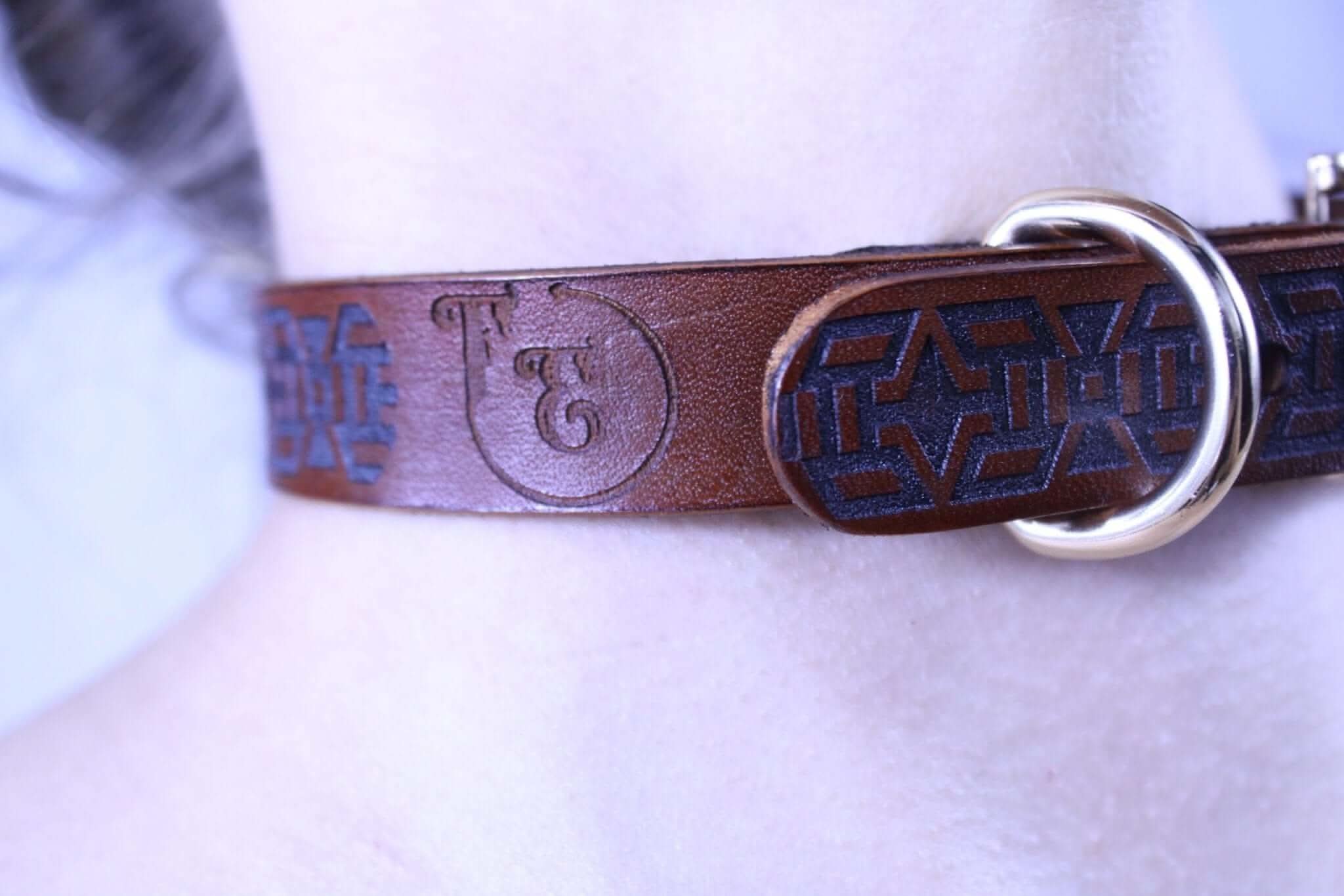 Handmade leather bondage collar with tribal motif, perfect for BDSM and discreet day wear, showcasing elegance and strength.
