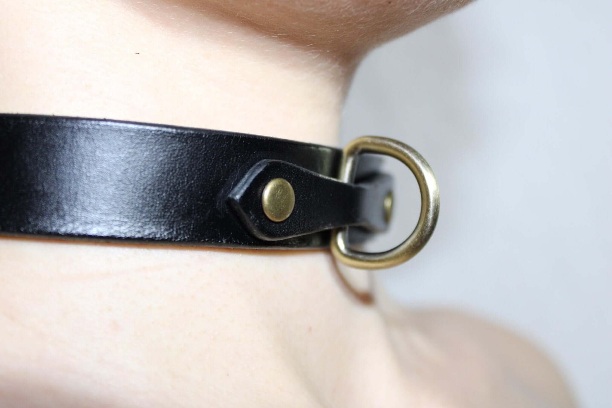 Minimalist black leather choker with metal ring, perfect for BDSM, submissive jewelry, and discreet day wear.