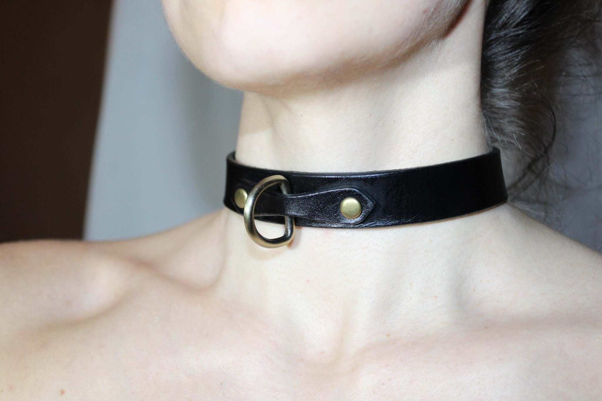 Minimalist black leather choker collar; a discreet submissive necklace for everyday BDSM style.