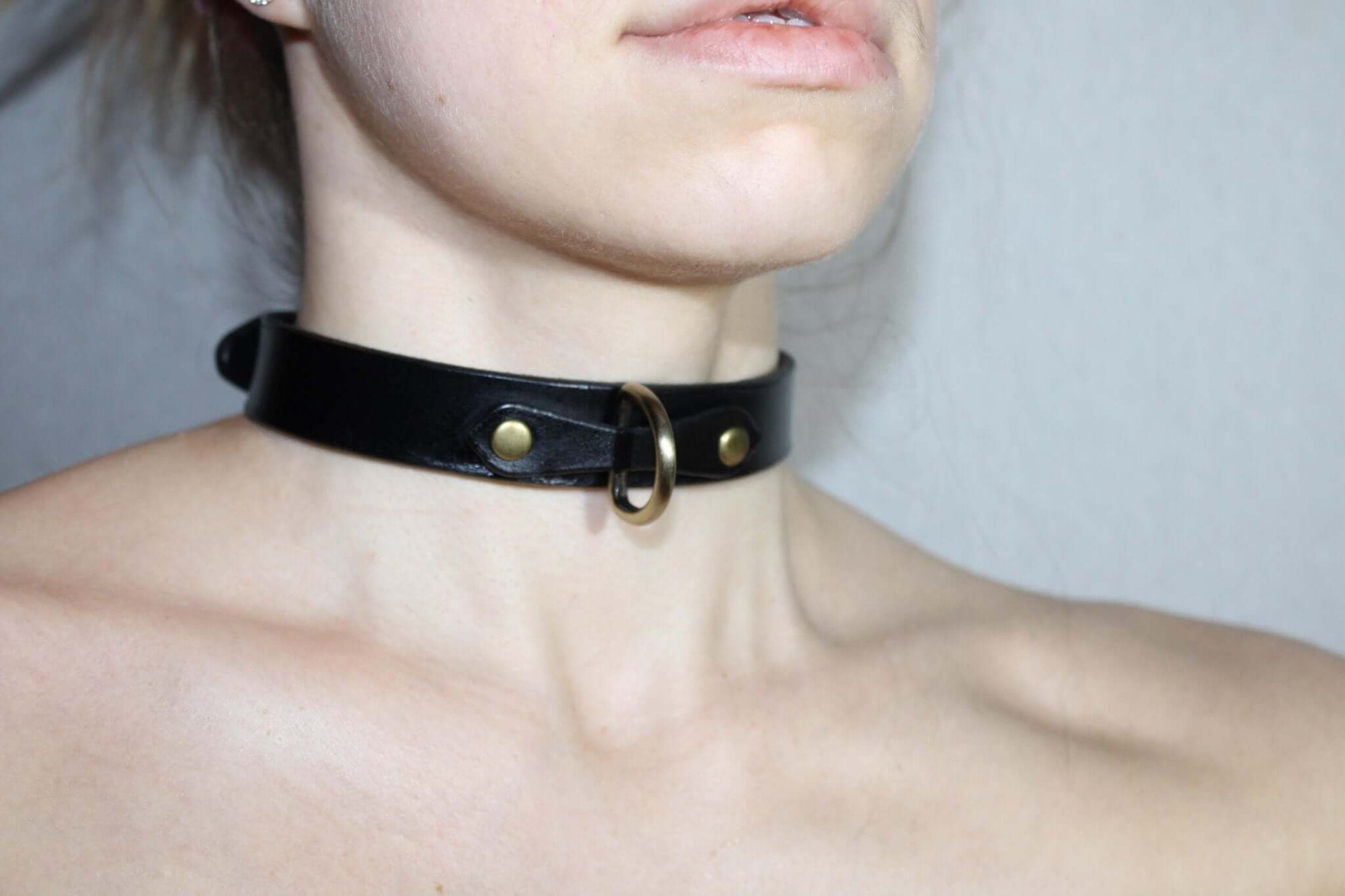 Minimalist black leather choker collar for discreet daywear, perfect for submissive jewelry and BDSM styles.