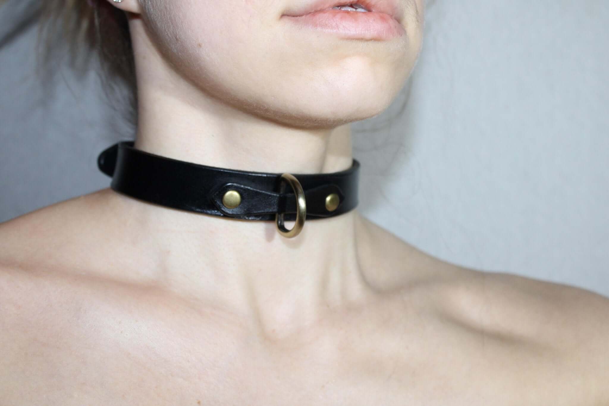 Minimalist black leather choker collar for discreet daywear, perfect for submissive jewelry and BDSM styles.