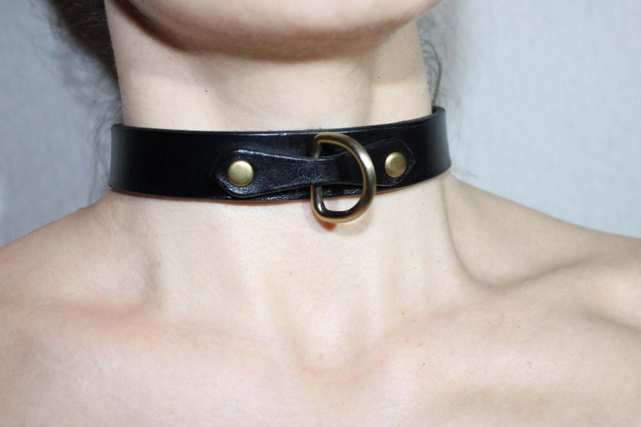 Minimalist black leather choker collar featuring a discreet design, ideal for submissive jewelry and everyday wear in BDSM fashion.