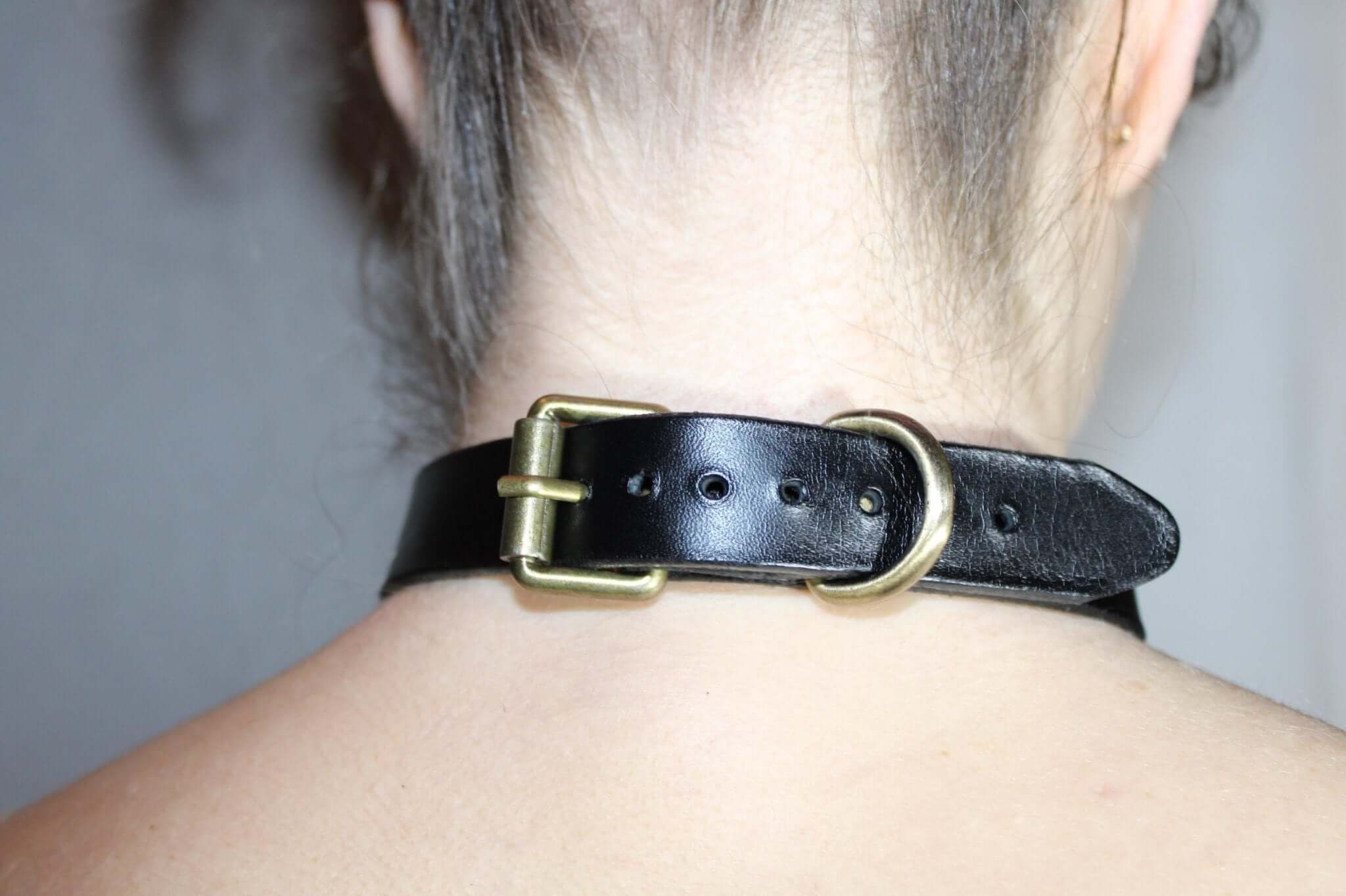 Back view of a minimalist black leather choker collar with gold buckle, ideal for discreet day wear and BDSM attire.