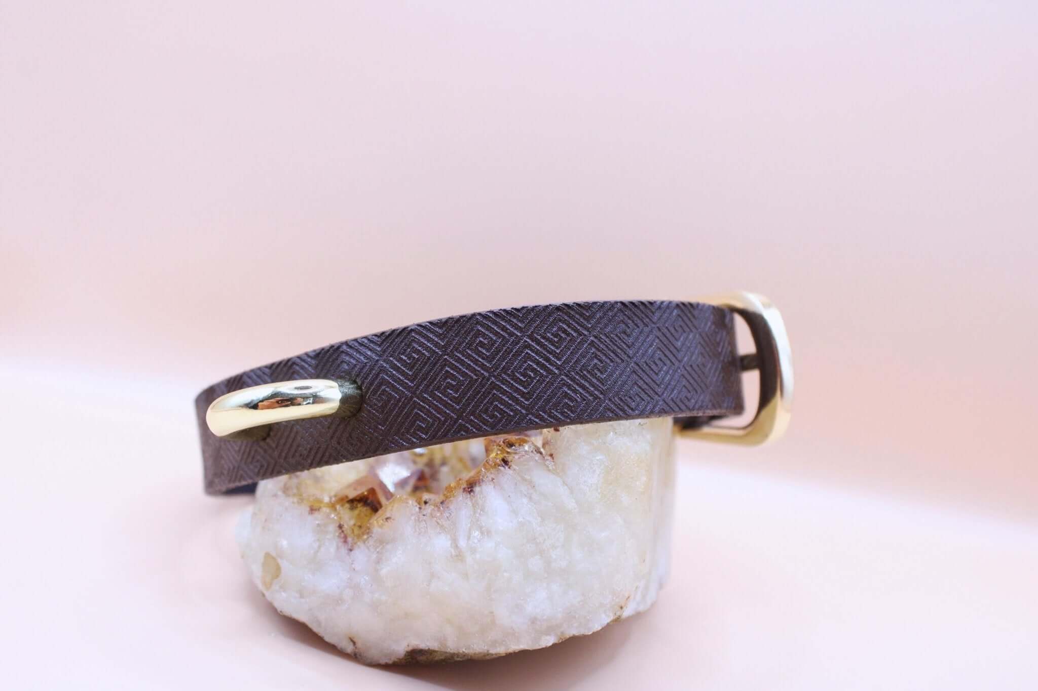 Minimalist BDSM collar made of dark brown leather with geometric design and gold accents, perfect for discreet sub jewelry.