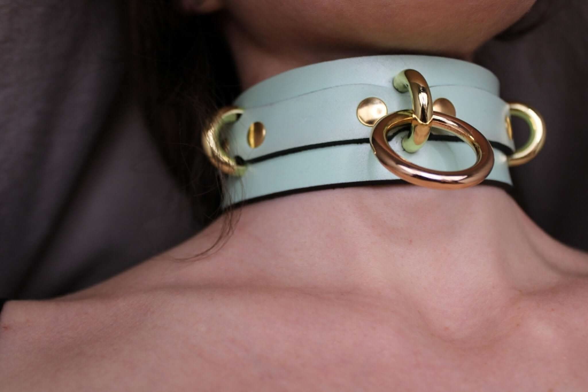 Mint green posture collar with gold O-ring, perfect as submissive jewelry and a stylish BDSM accessory.