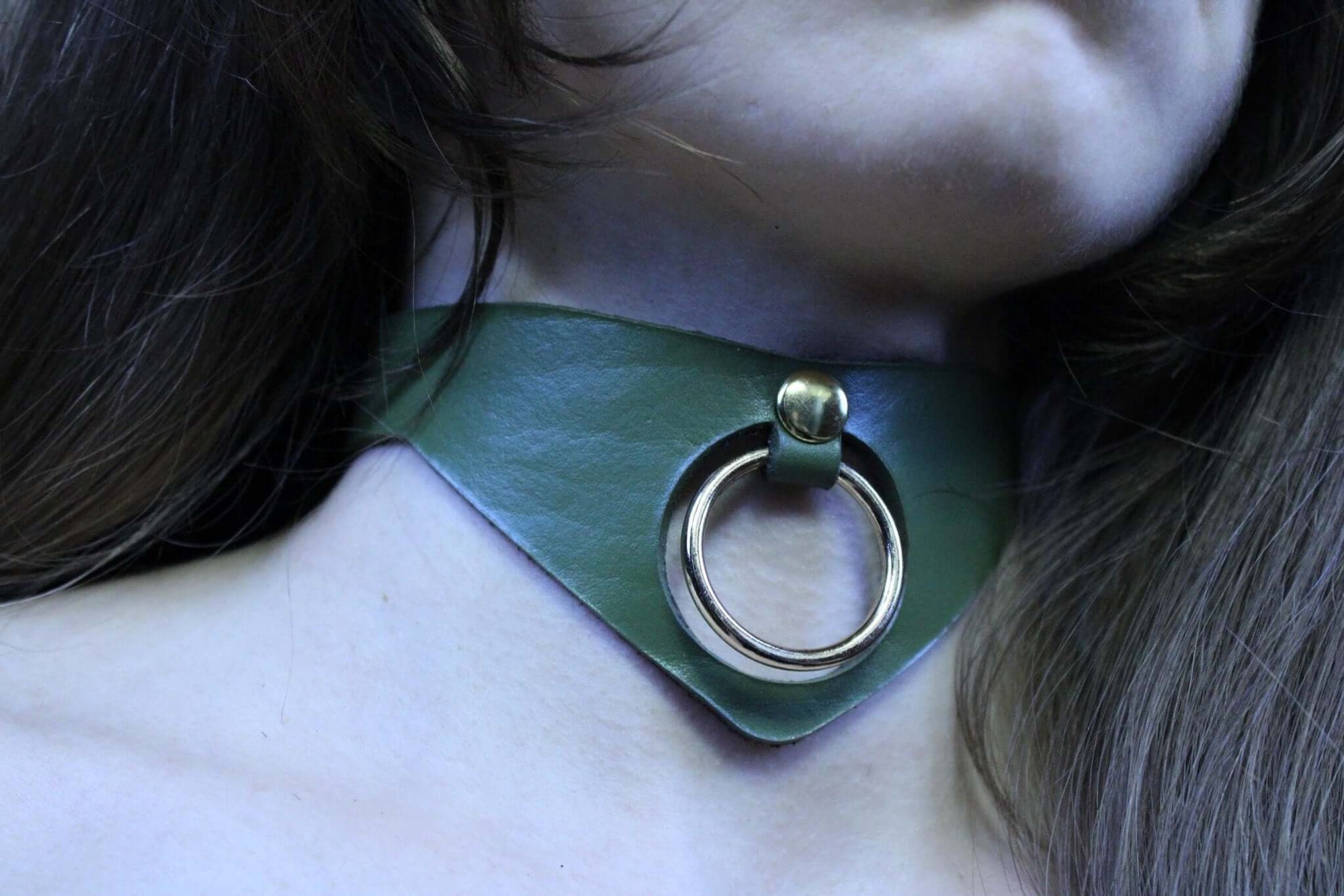 Olive green posture collar with bold O-ring; perfect submissive jewelry for bondage and BDSM enthusiasts.